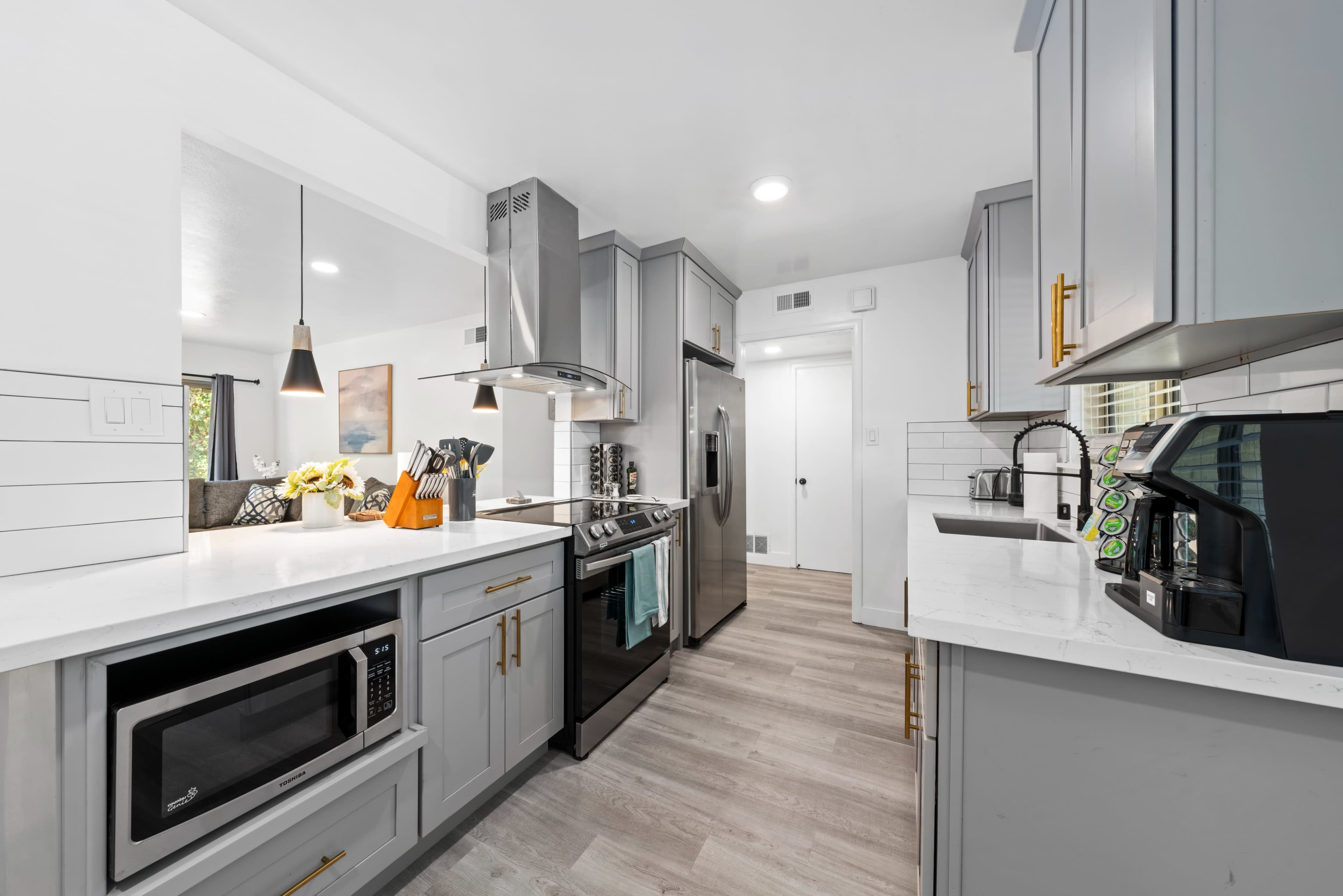 The kitchen features modern cabinetry, stainless steel appliances, and a light-colored countertop.