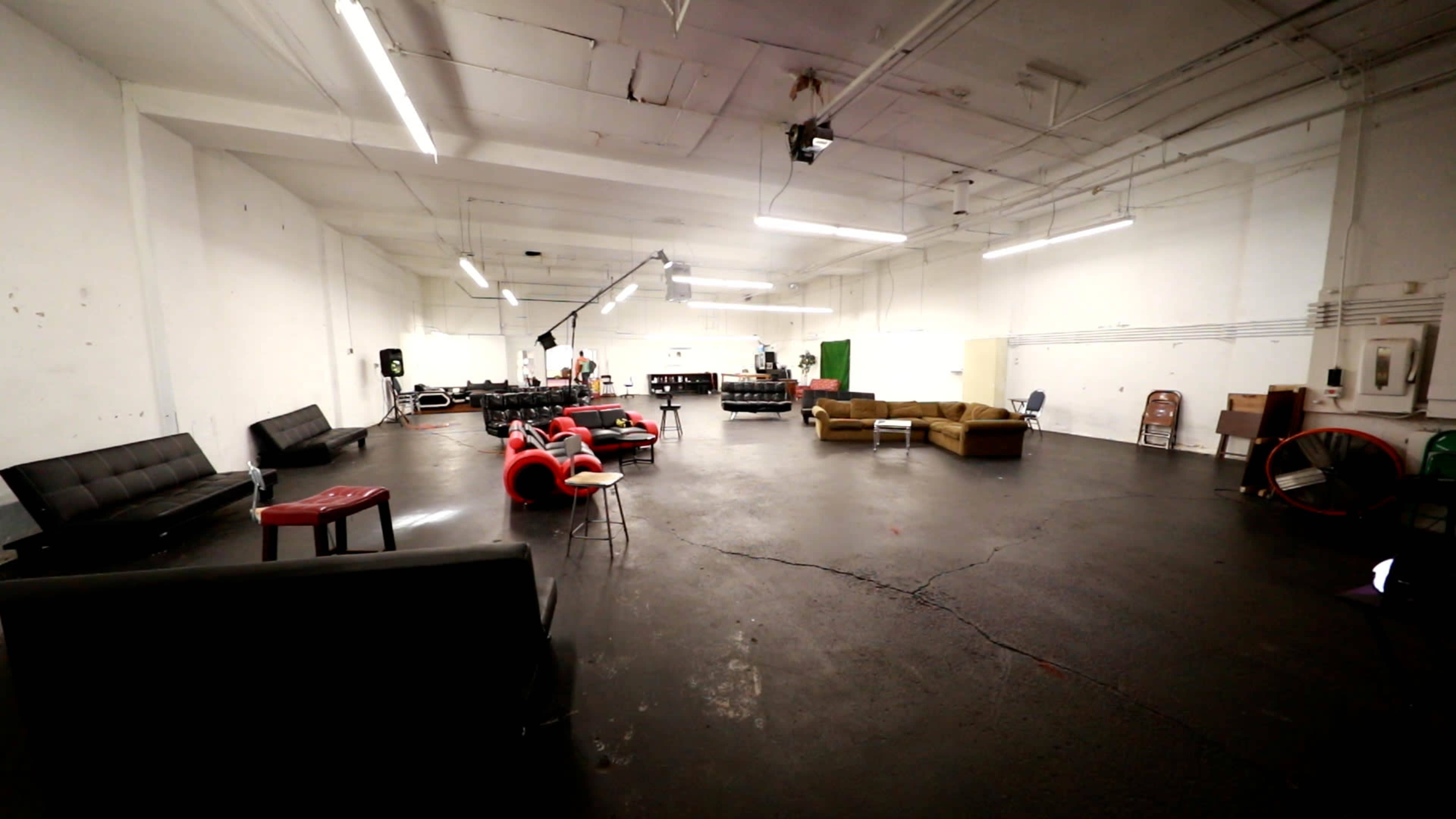 A spacious, empty room with various couches and chairs arranged around the area.