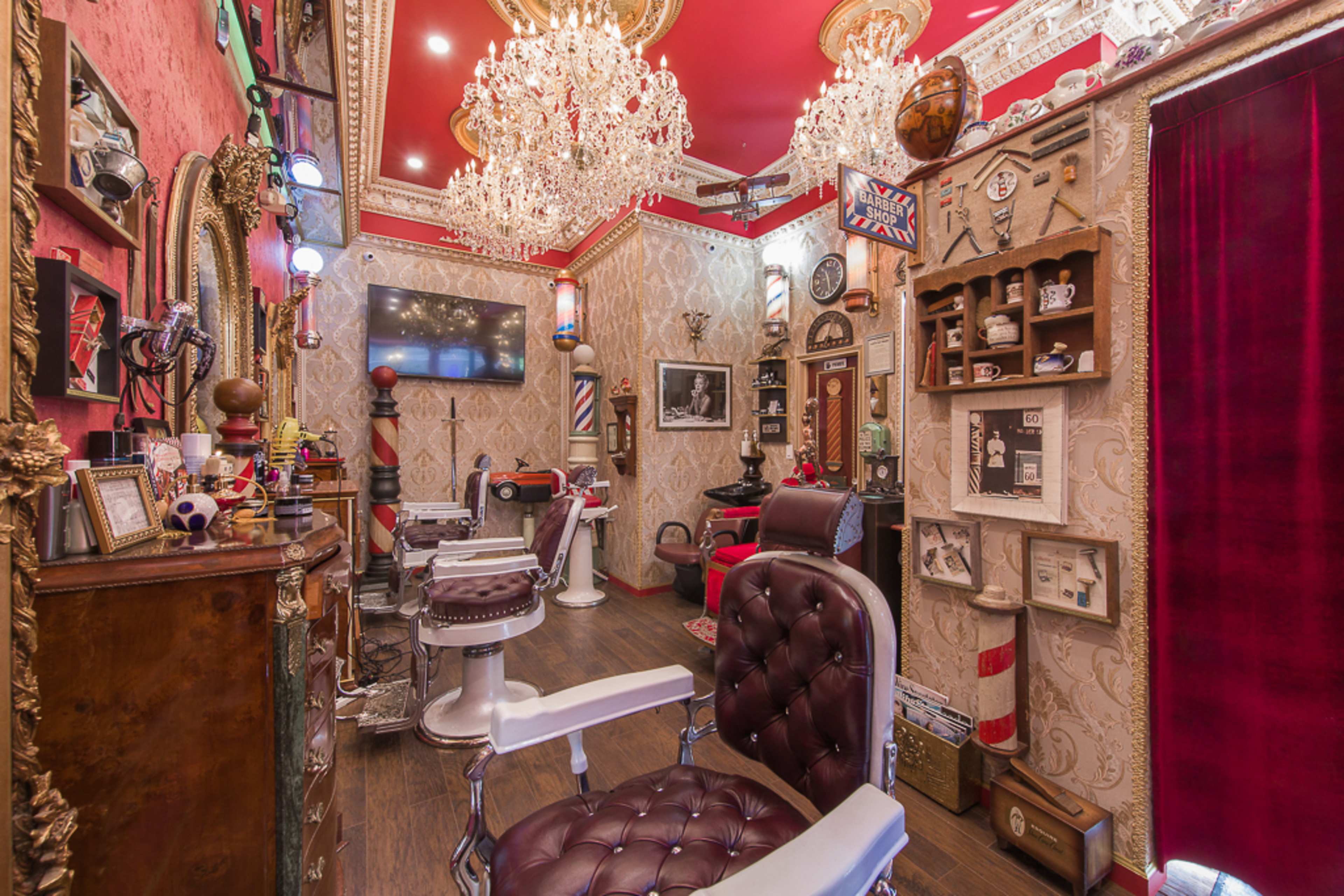 A vintage-style barber shop adorned with ornate decorations, chandeliers, and barber chairs.