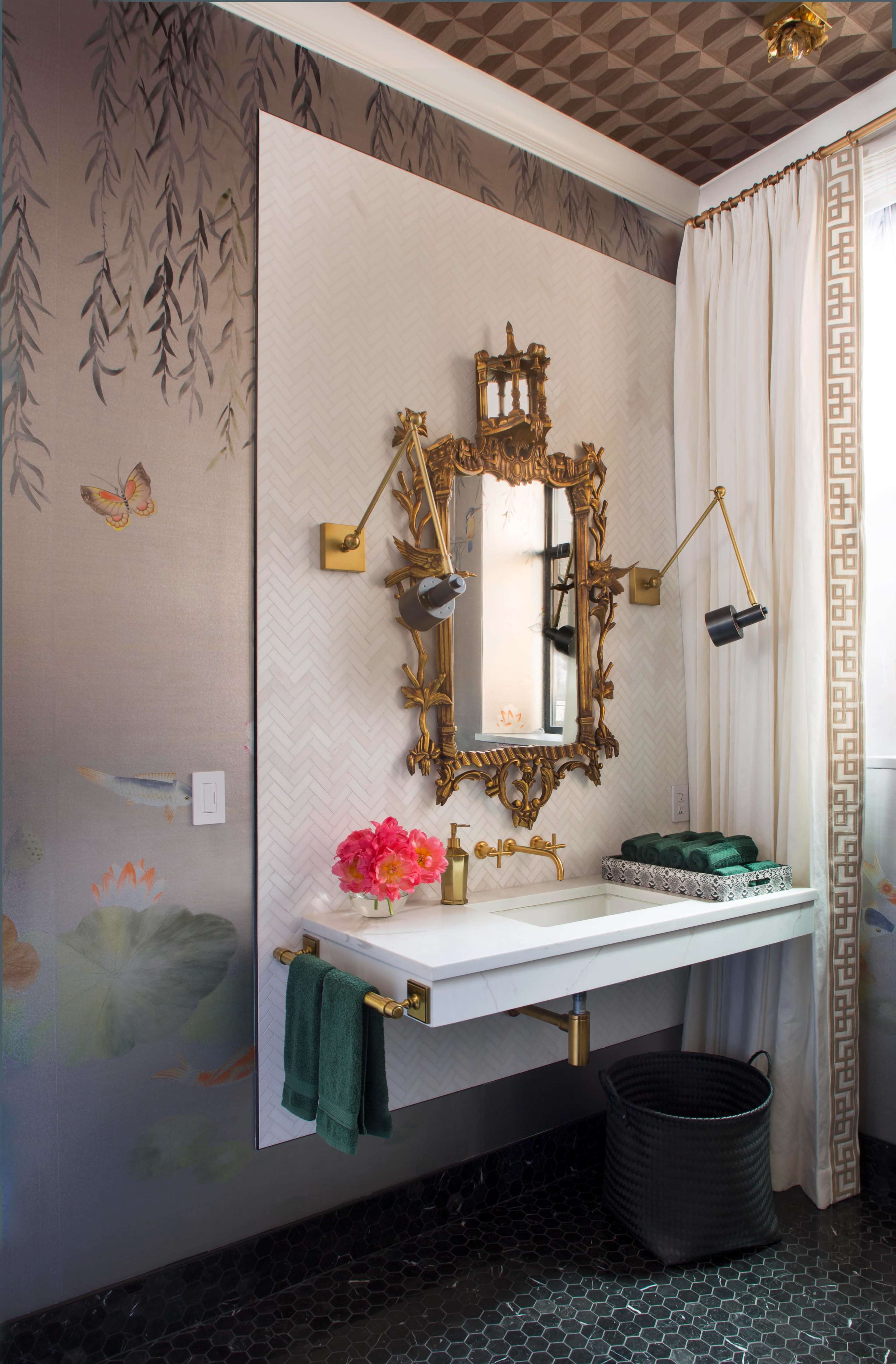 The image shows a stylish bathroom with a wall-mounted sink, an ornate mirror, floral decorations, and patterned wallpaper.