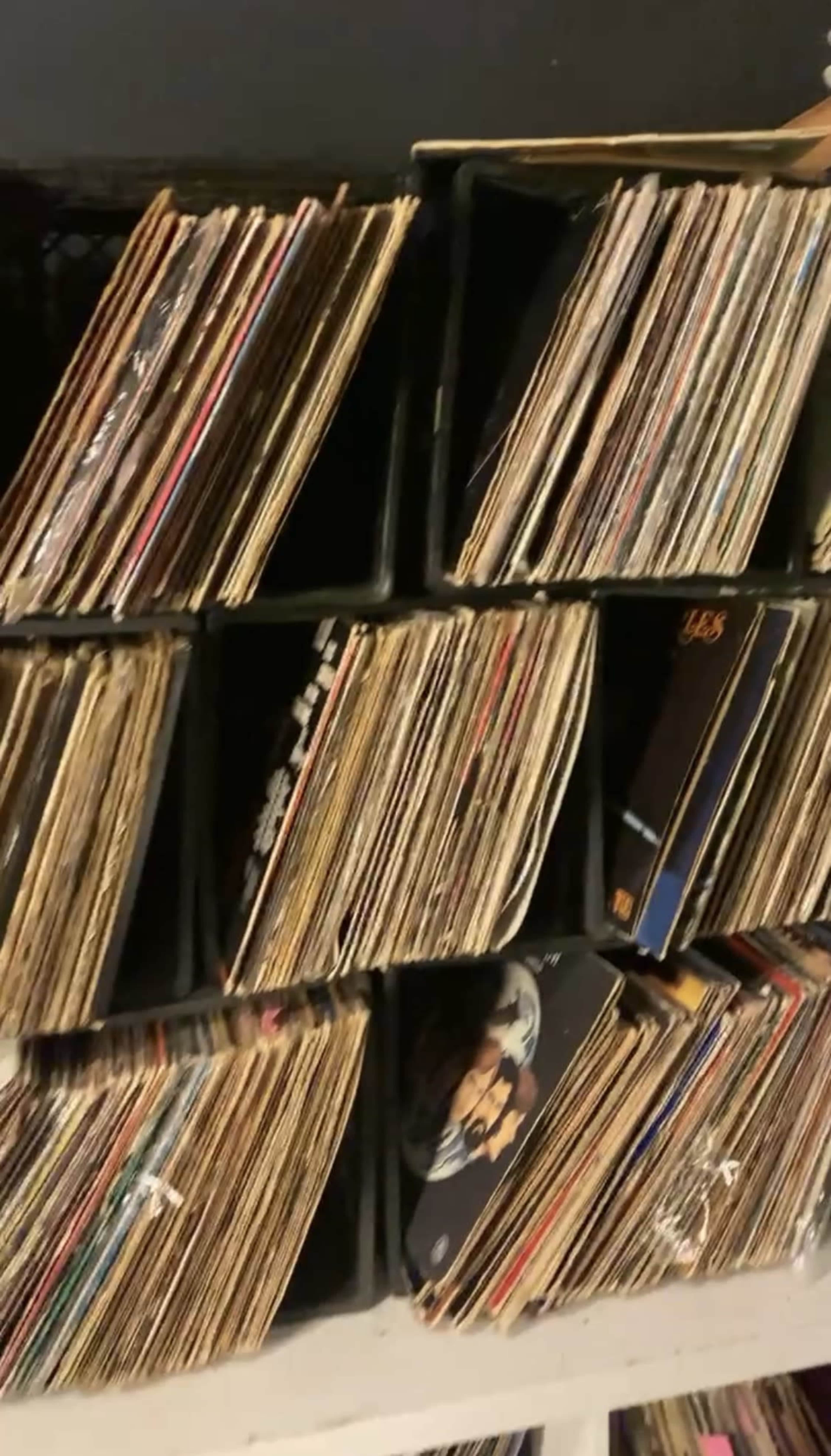 The image shows a collection of vinyl records organized in cubby-like shelves.