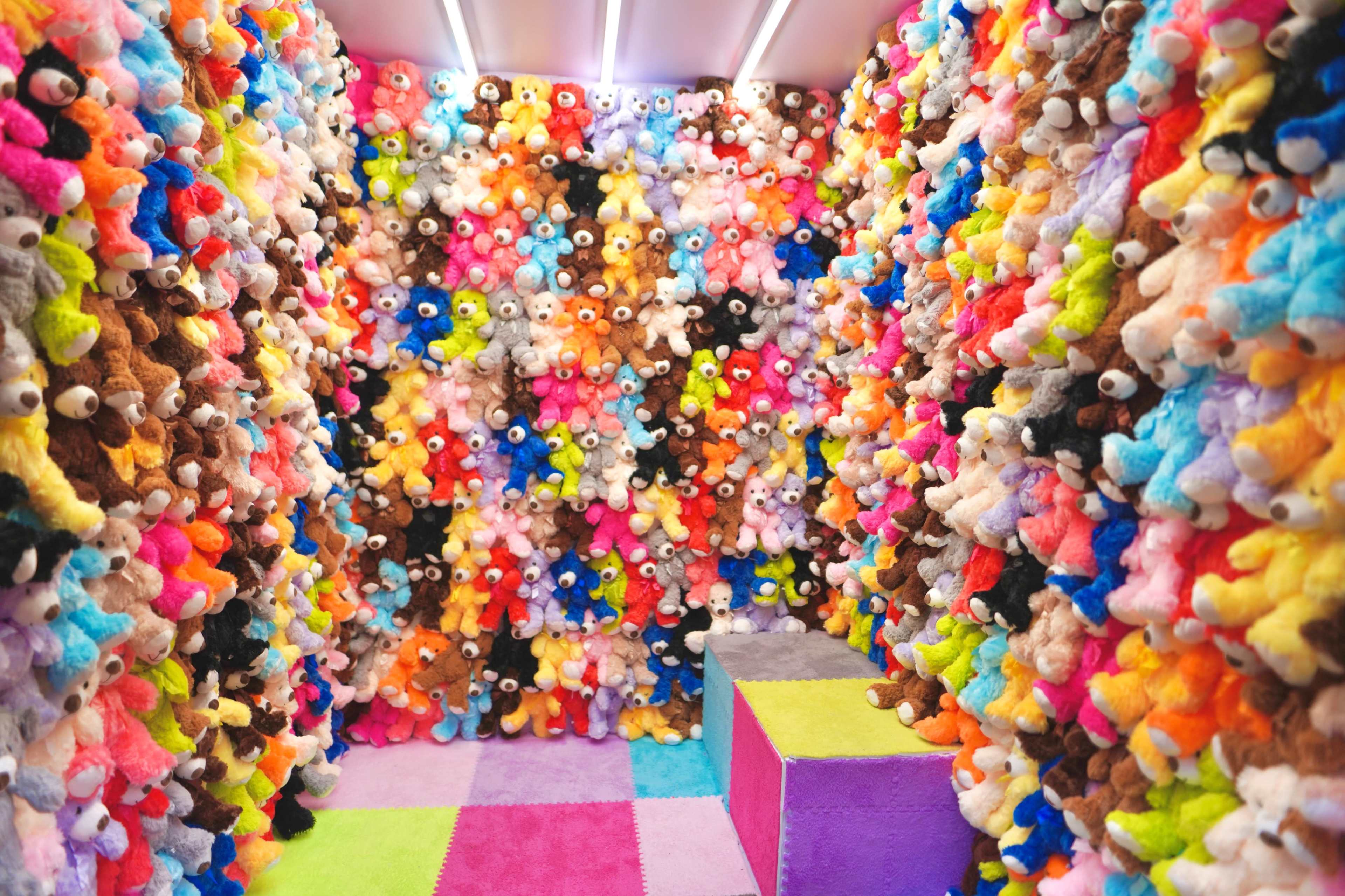 A room filled with colorful stuffed animals covering the walls and creating a vibrant, plush environment.