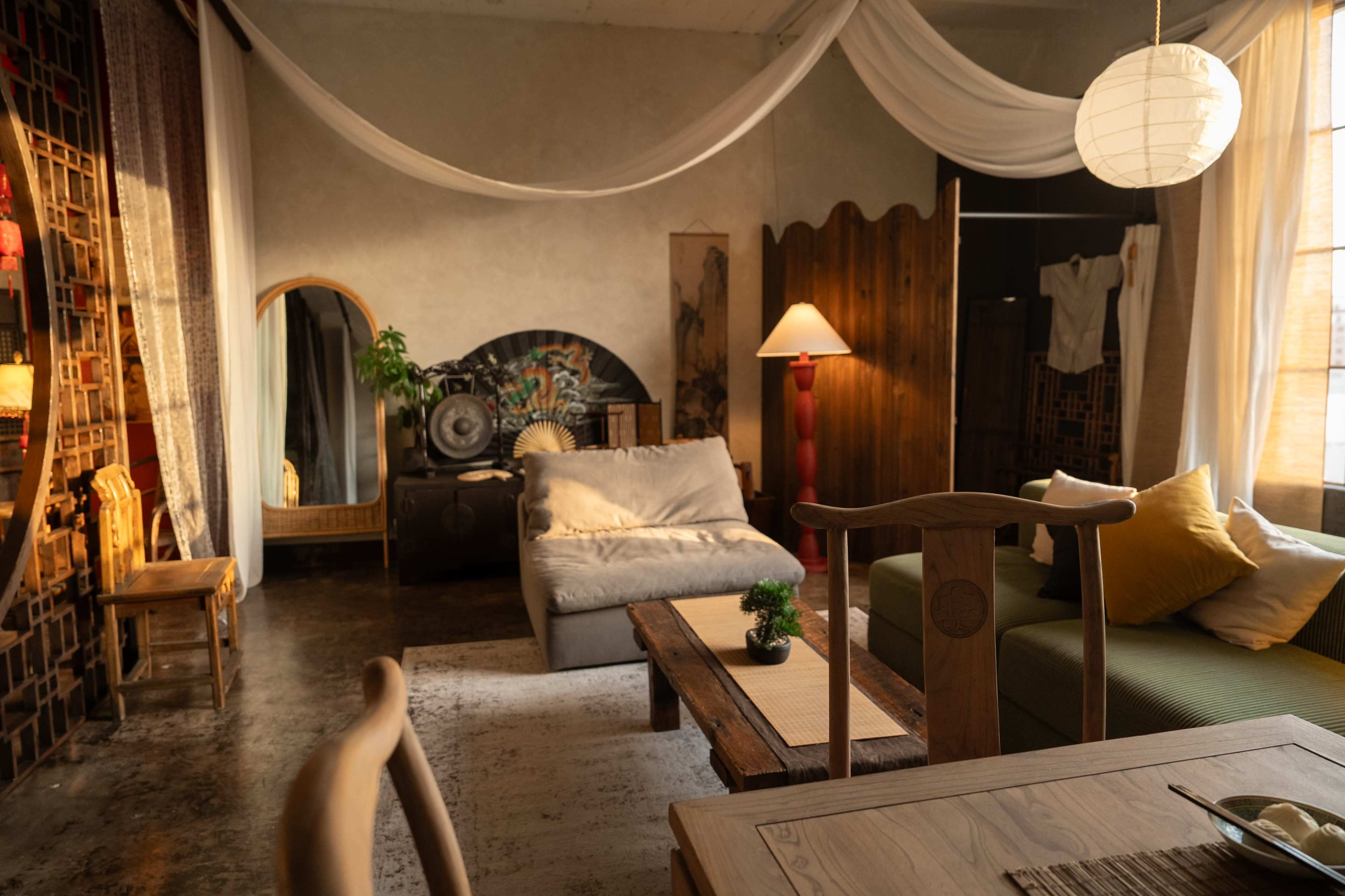 A cozy living room with a mix of modern and traditional furniture, including a sofa, a wooden coffee table, and decorative elements like a floor lamp and wall art.