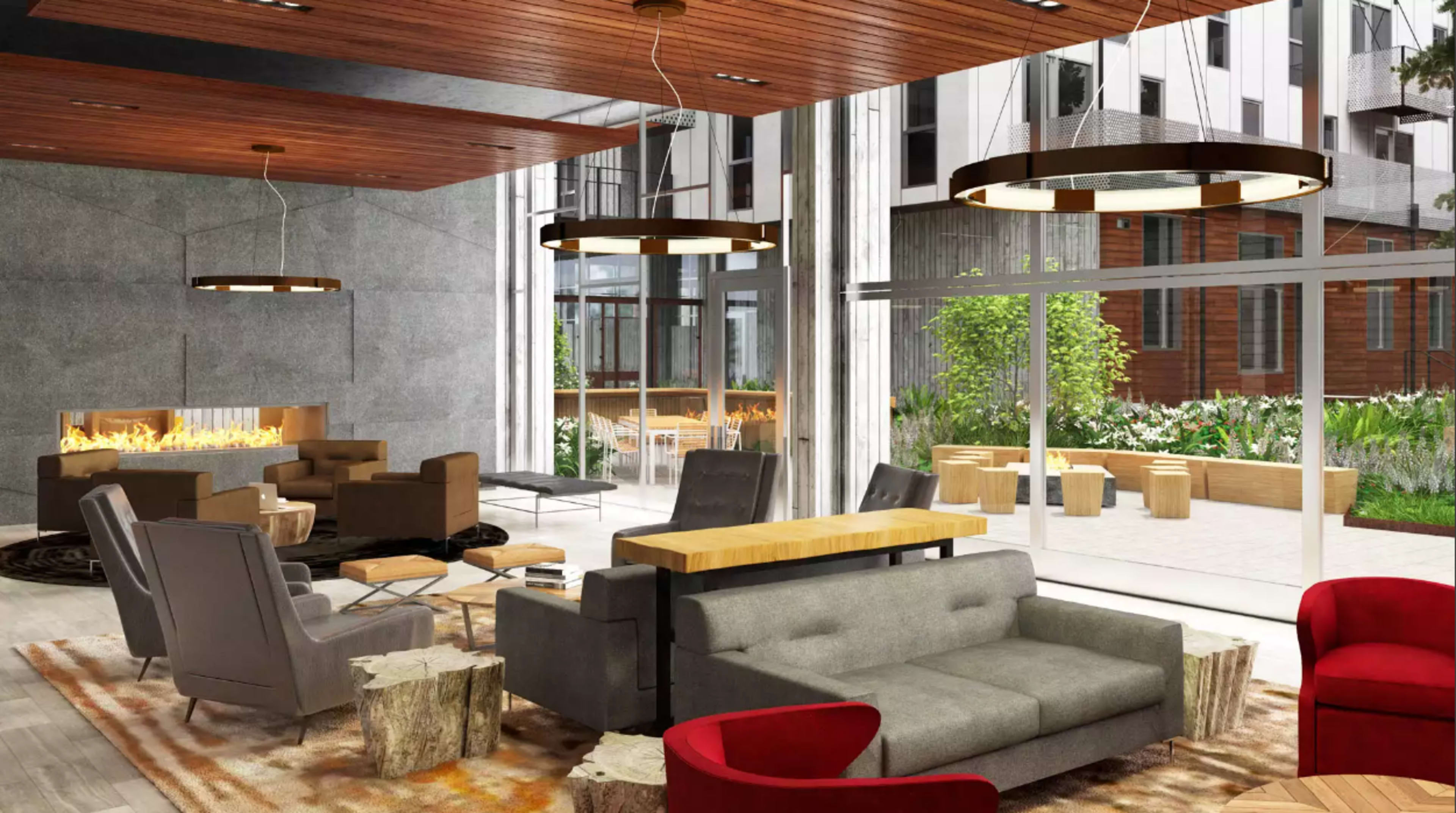 A modern lounge area featuring a fireplace, comfortable seating, large windows, and a garden view.