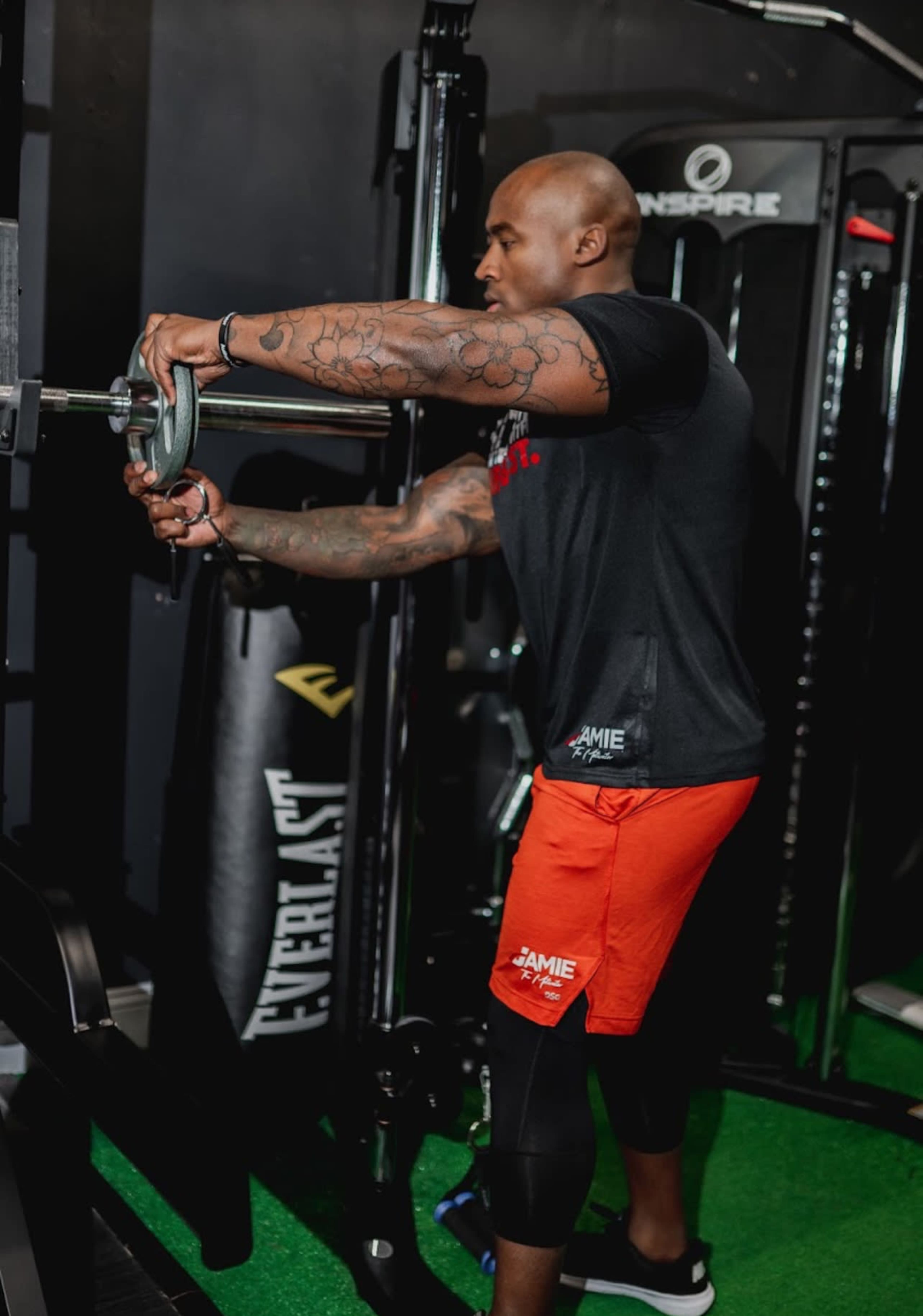 A man is adjusting weights on a fitness machine in a gym.