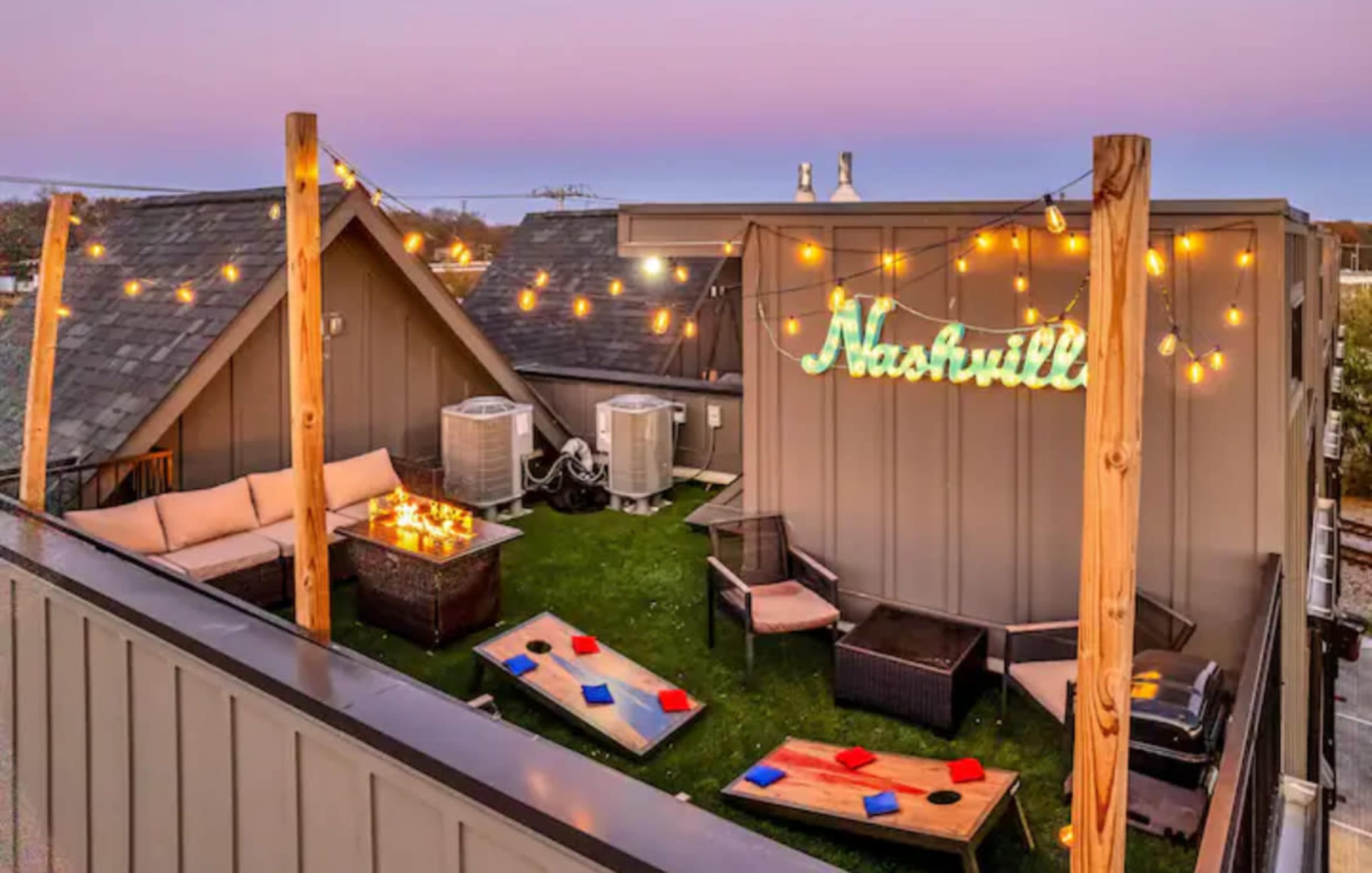 The rooftop terrace features string lights, seating areas, and a neon sign that reads "Nashville."