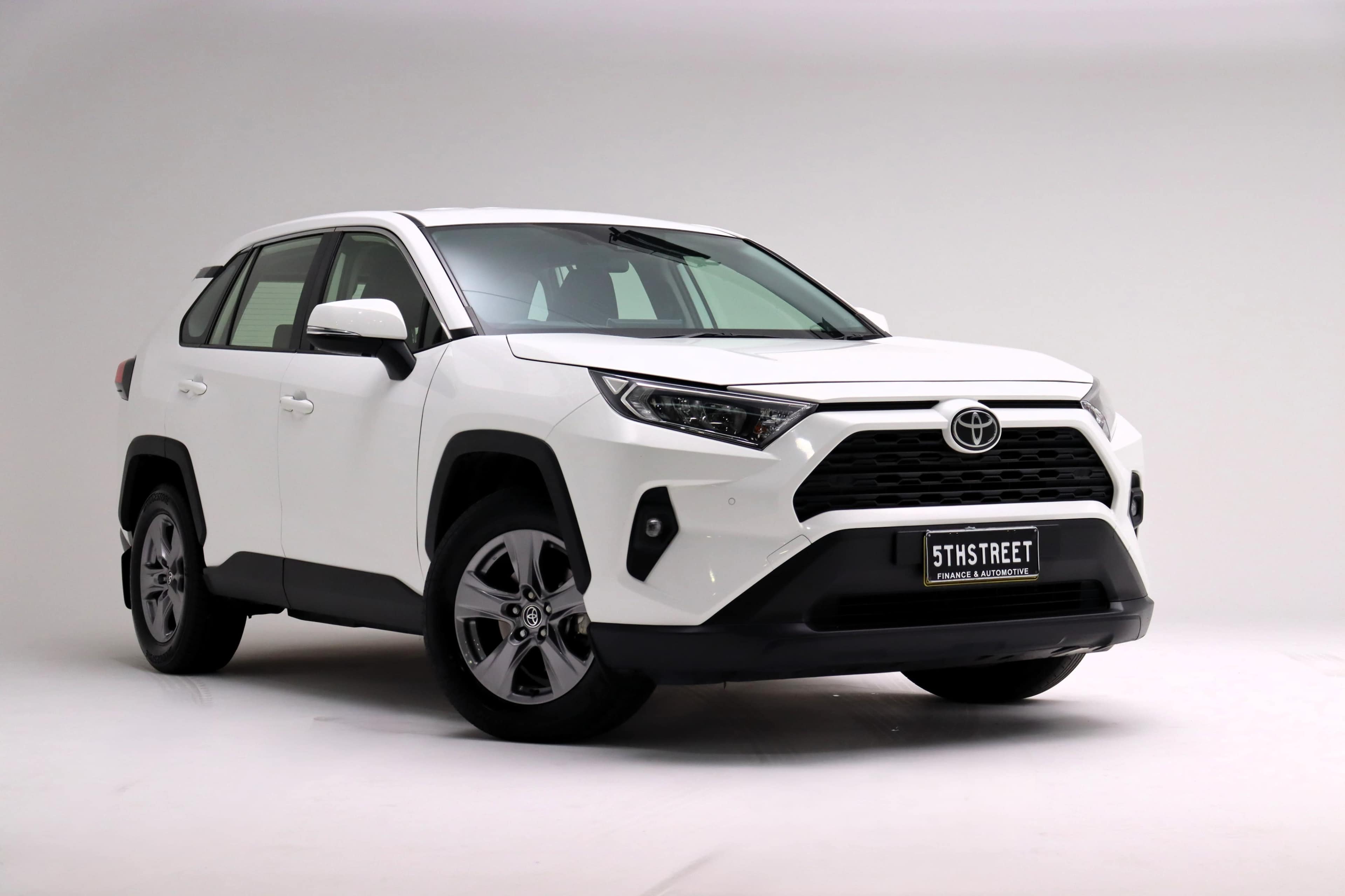 The image shows a white Toyota RAV4 parked on a plain background.