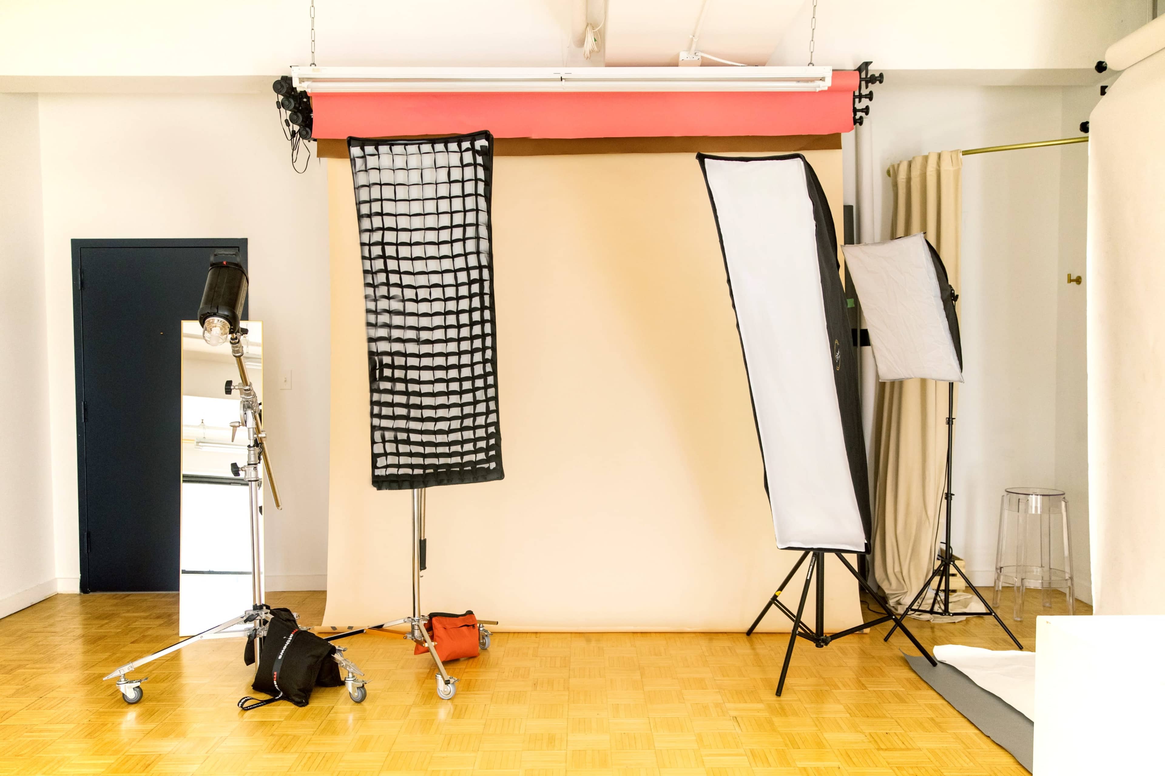 A photography studio setup with a light stand, softboxes, and a neutral backdrop.