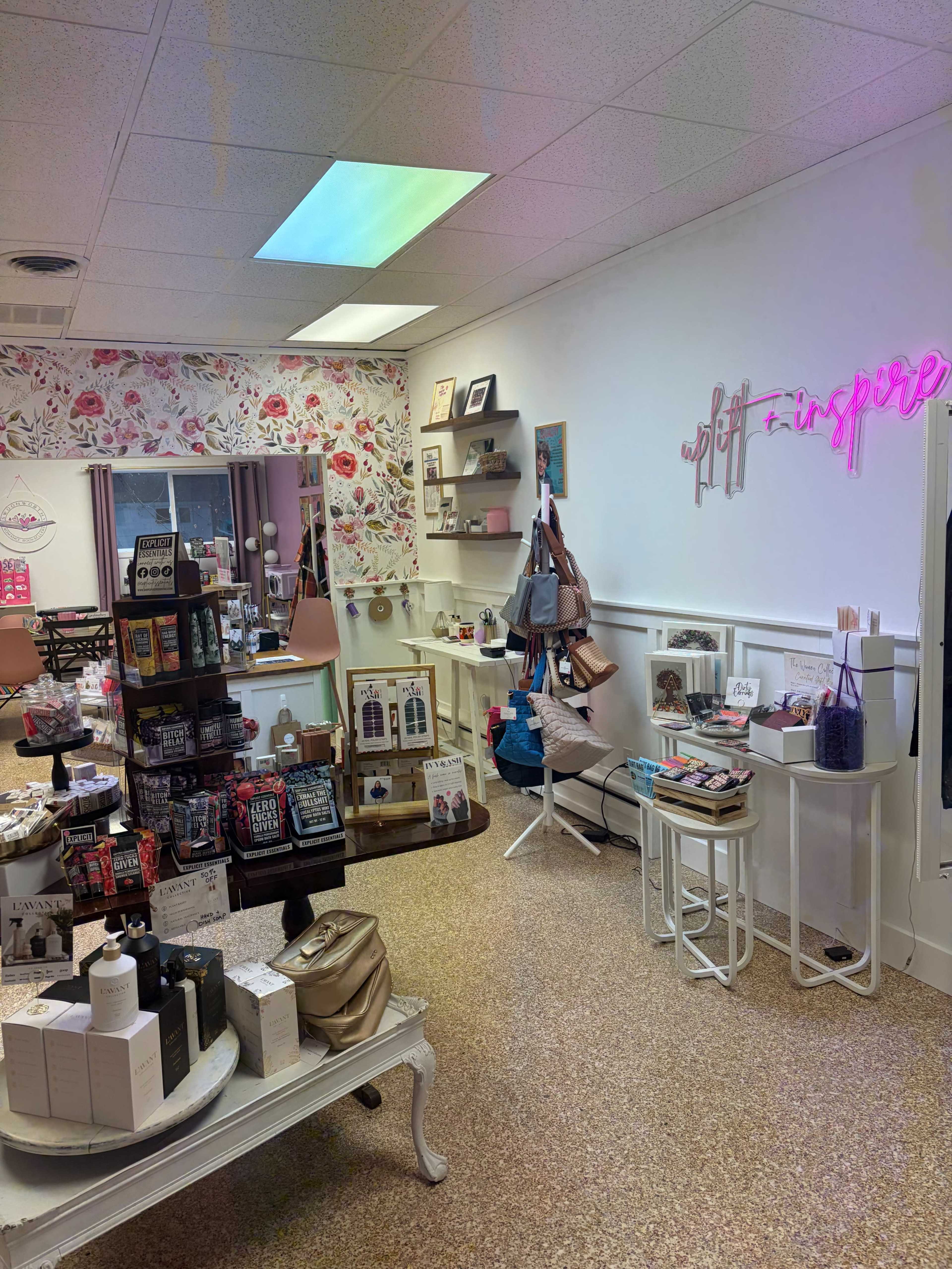 The image shows a boutique interior featuring shelves of various gift items, decorative displays, and floral wallpaper.