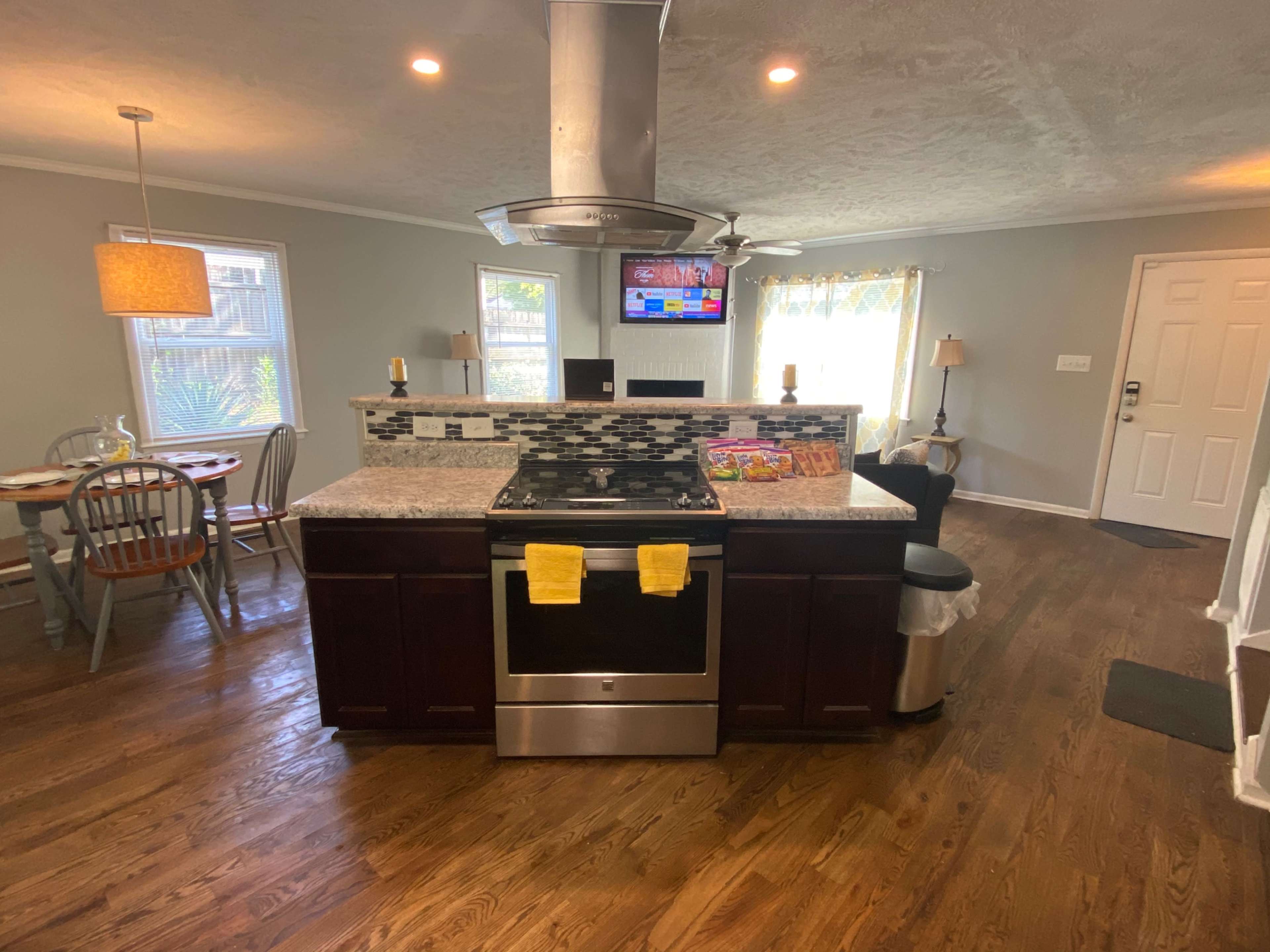 A modern kitchen with a central island, stainless steel appliances, and an adjacent dining area.