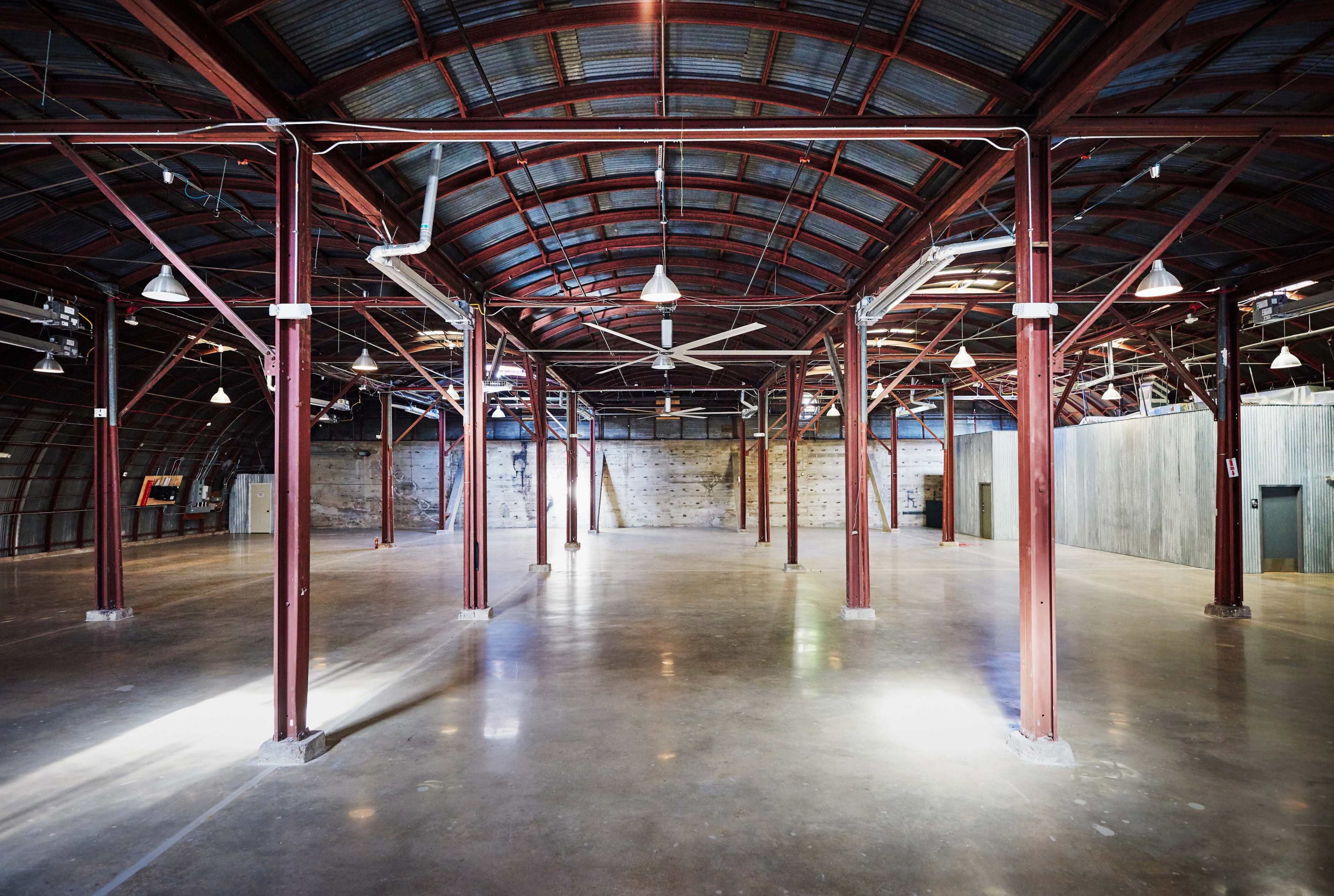 A spacious, industrial-style interior with metal beams and a polished concrete floor.