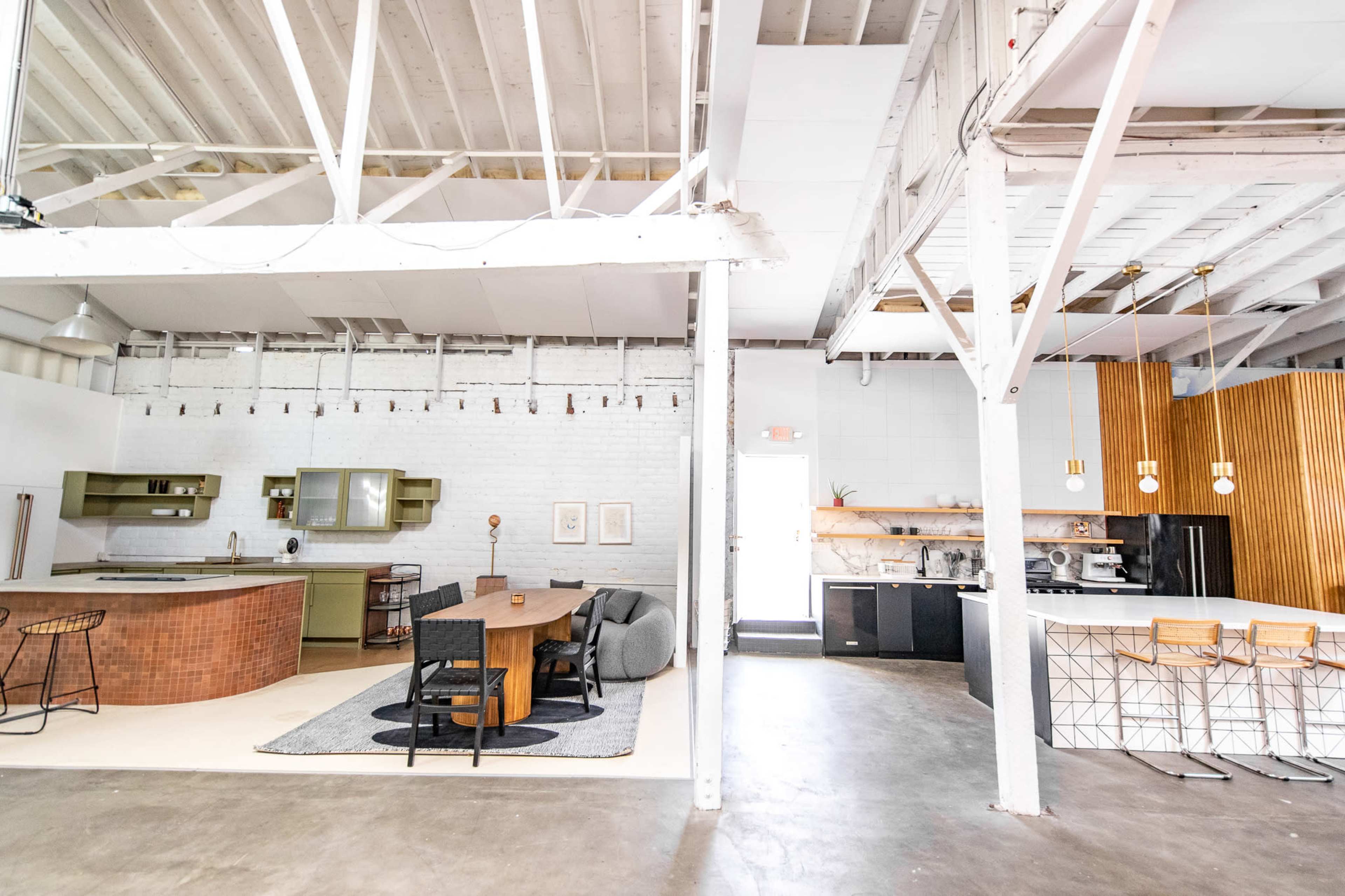 A spacious, open-concept kitchen and dining area with modern finishes and a combination of brick and wood elements.