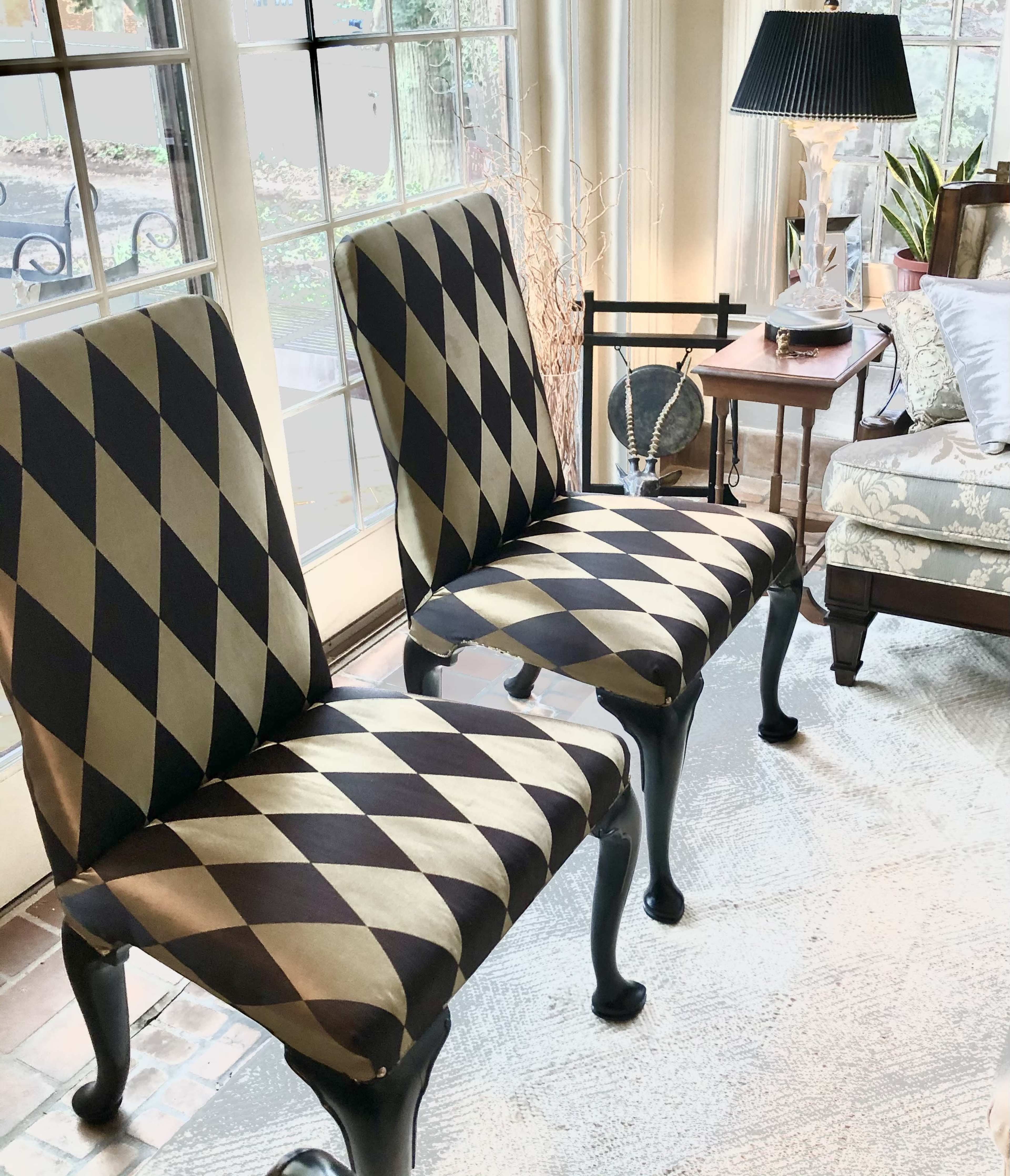 Two patterned chairs with an argyle design placed in a bright room with large windows.