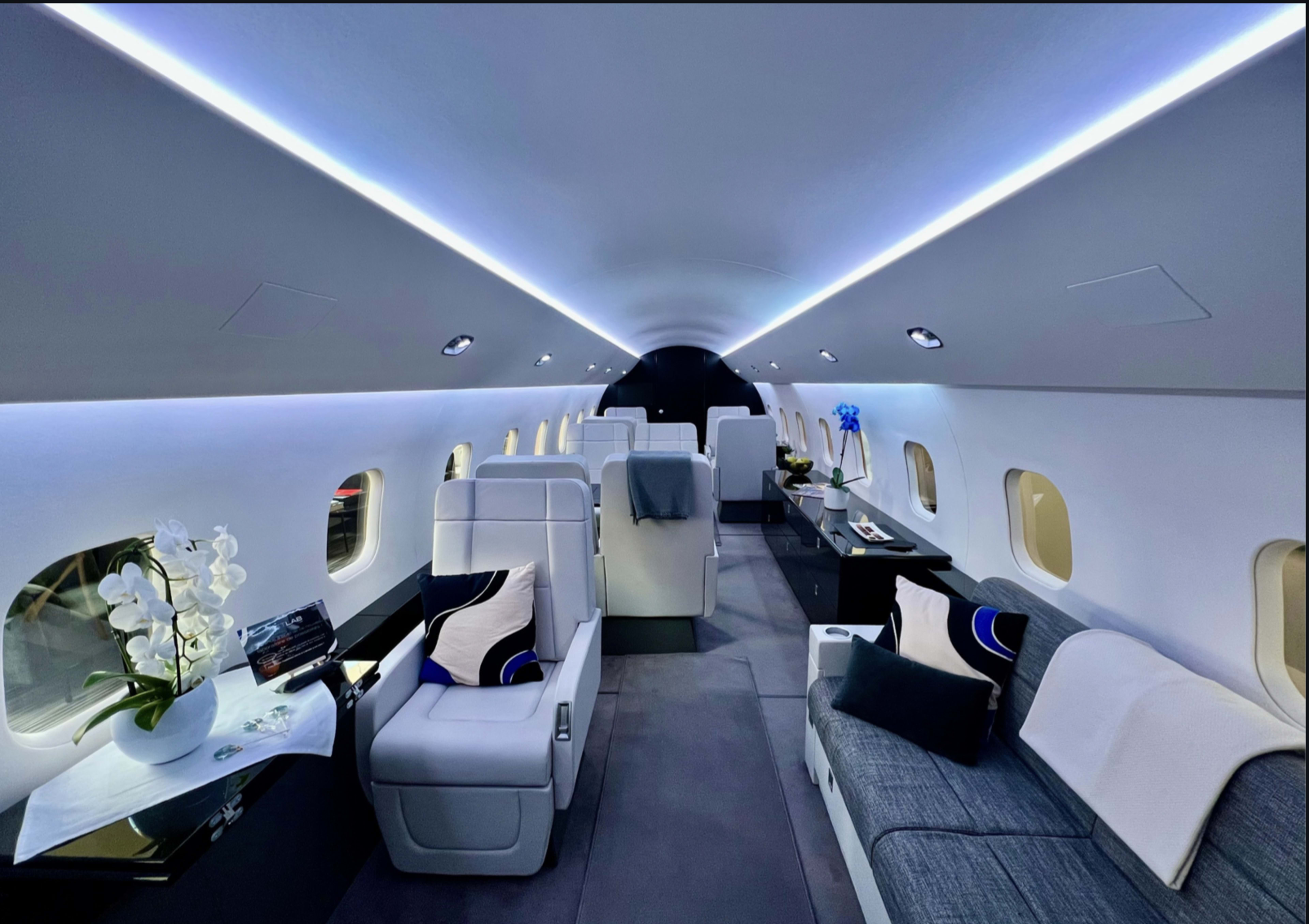 The interior of a private jet features plush seating, modern decor, and ambient LED lighting.