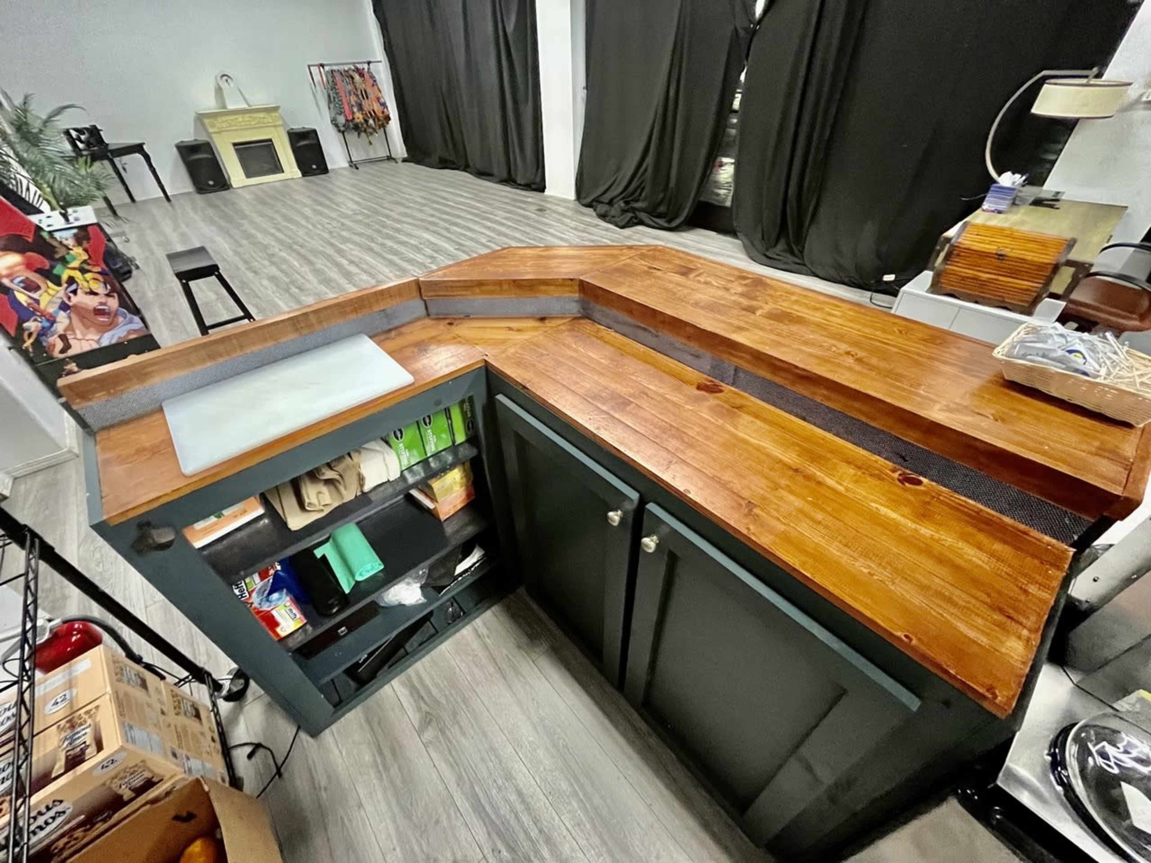 A wooden counter with a polished surface, featuring a unique angular design and integrated storage beneath it.