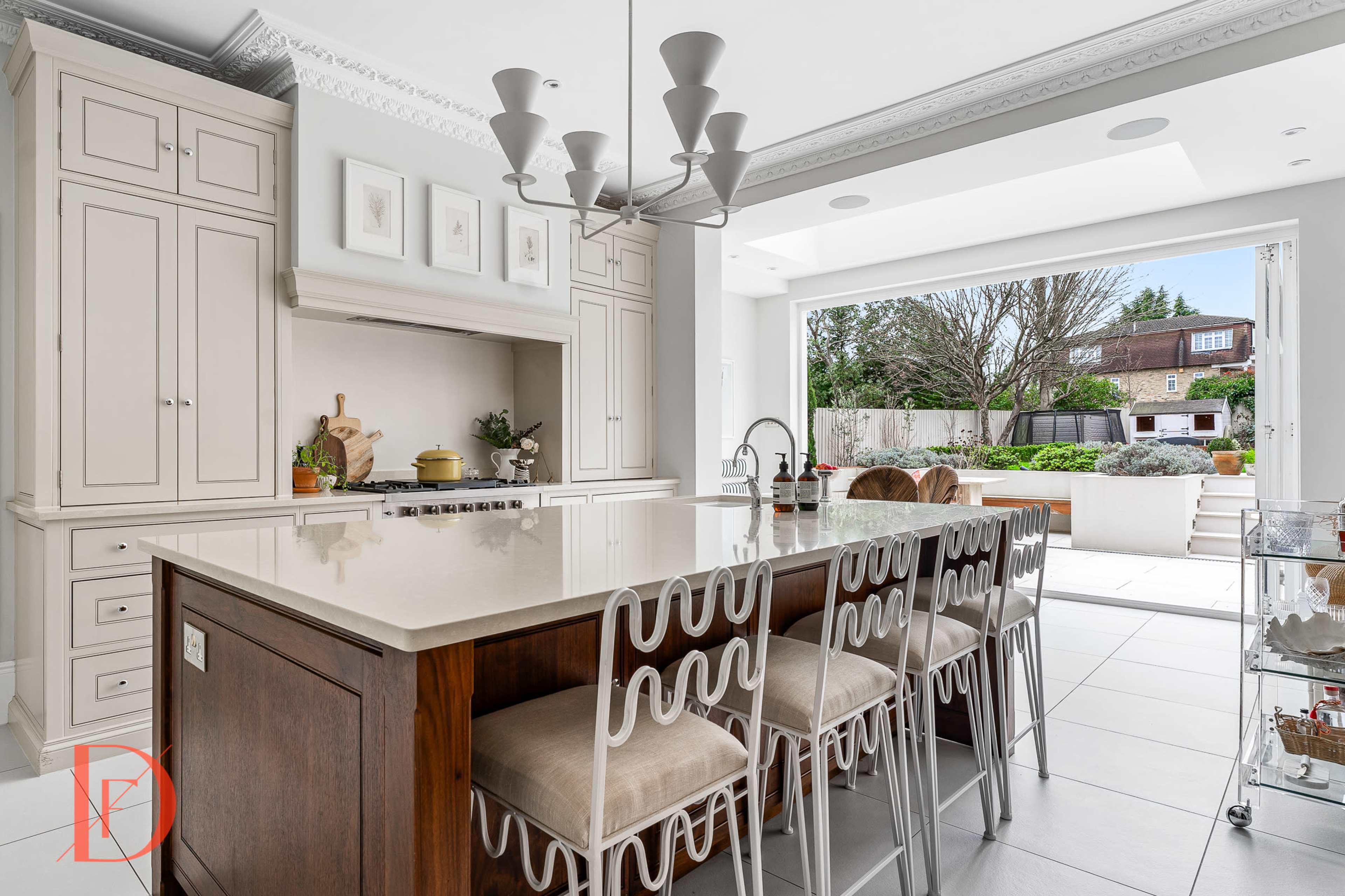 A modern kitchen with a large island featuring seating, stylish cabinetry, and an open layout leading to an outdoor space.