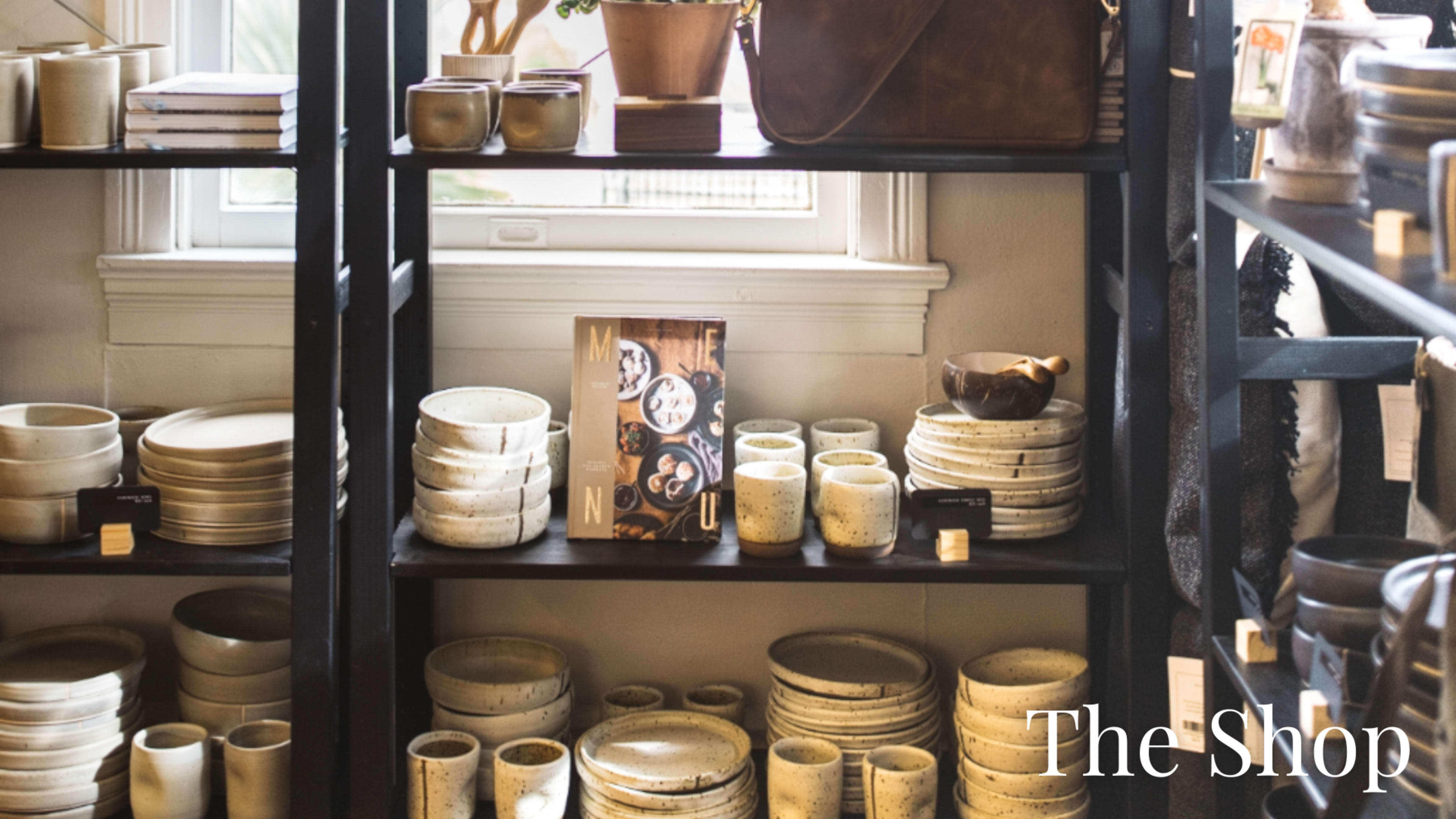 The image shows shelves filled with various ceramic dishes and pots in a shop.