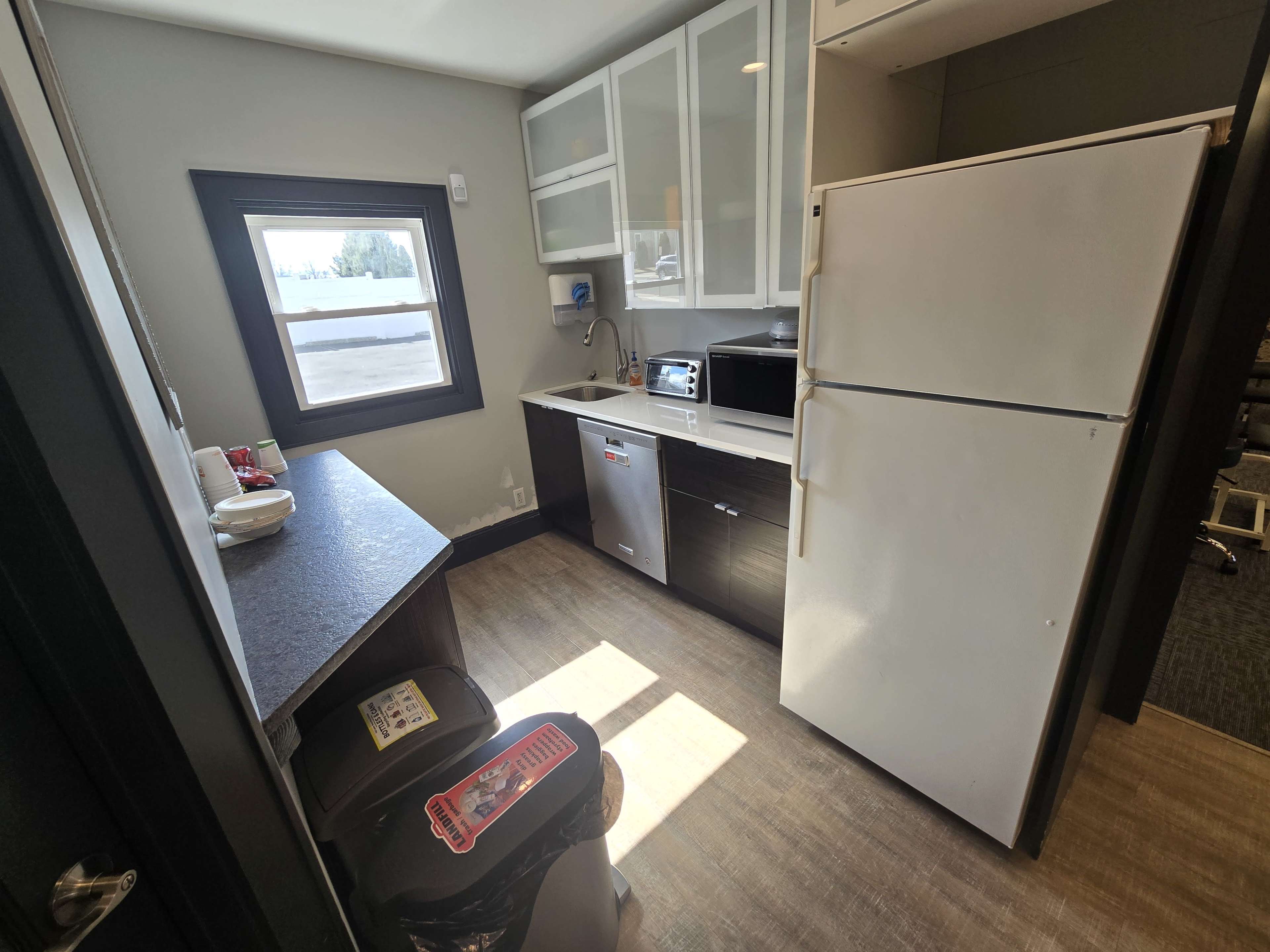 The kitchen features modern appliances, including a refrigerator, microwave, and a small countertop, within a compact layout.