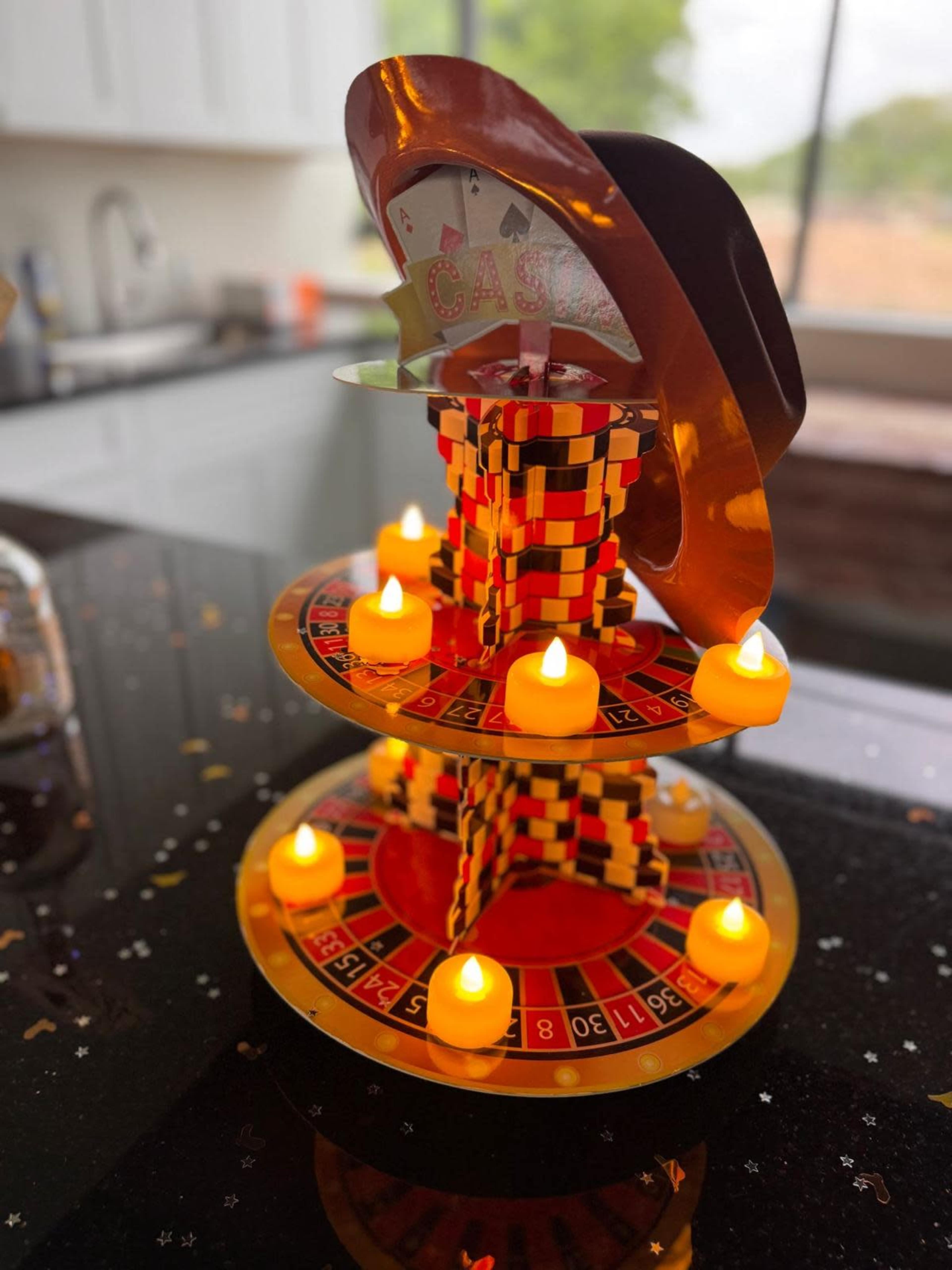 The image shows a multi-tiered roulette display decorated with a cowboy hat and surrounded by small LED candles.