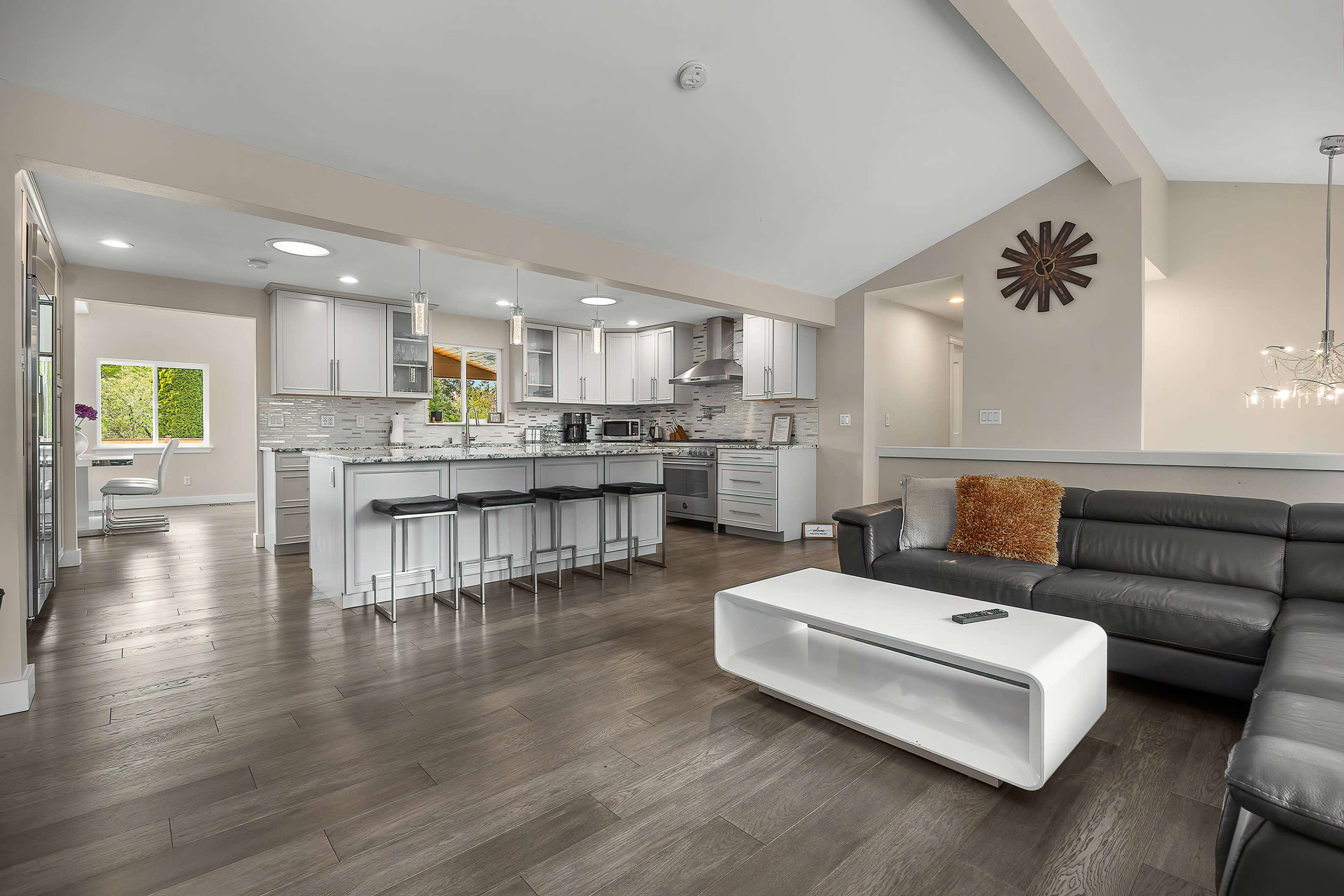 A modern open-concept living room and kitchen with sleek cabinetry and a comfortable seating area.