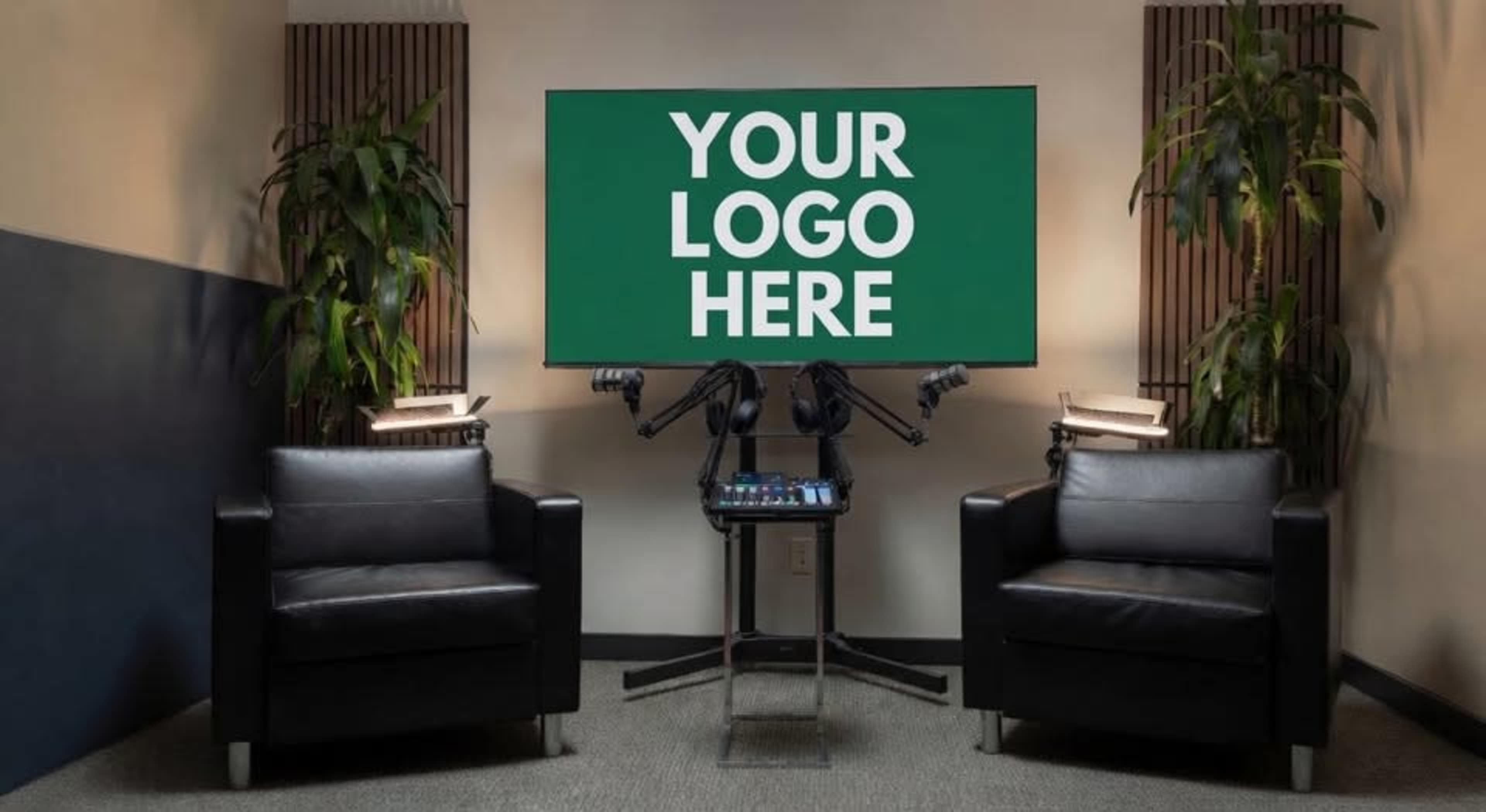 The image shows a set designed with two black chairs facing a large screen that displays the text "YOUR LOGO HERE," accompanied by potted plants on either side.