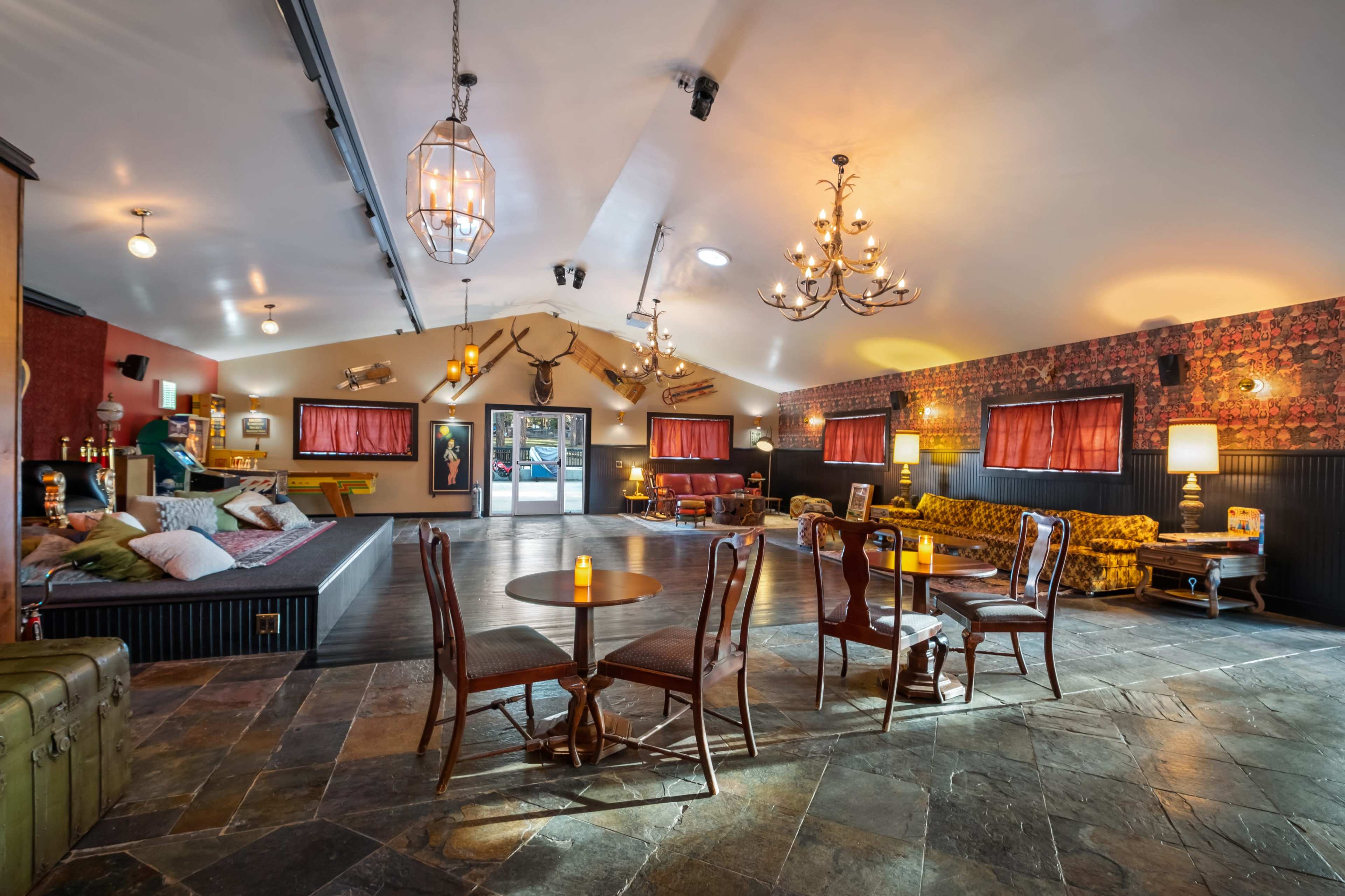 A spacious interior with a combination of seating areas, decorative lighting, and patterned walls.