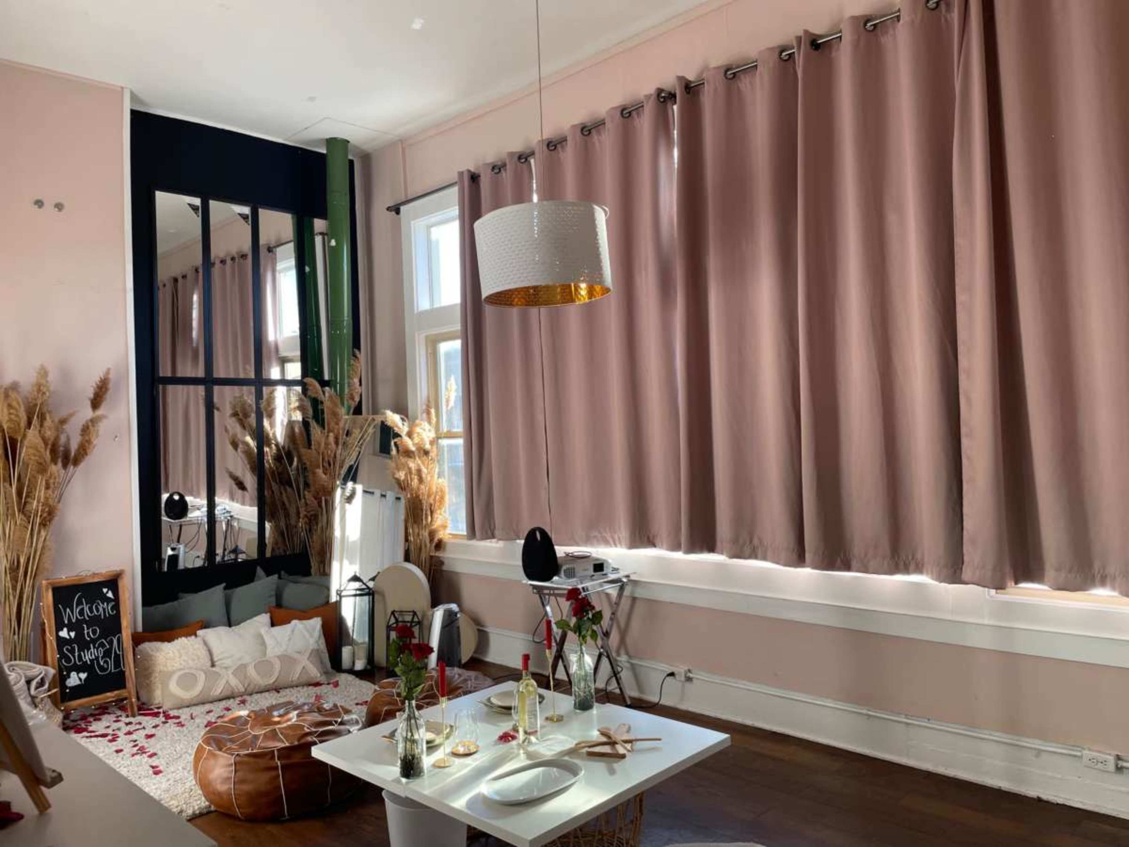 The room features a cozy setup with a floor seating area, a low table, and large curtains covering the windows.