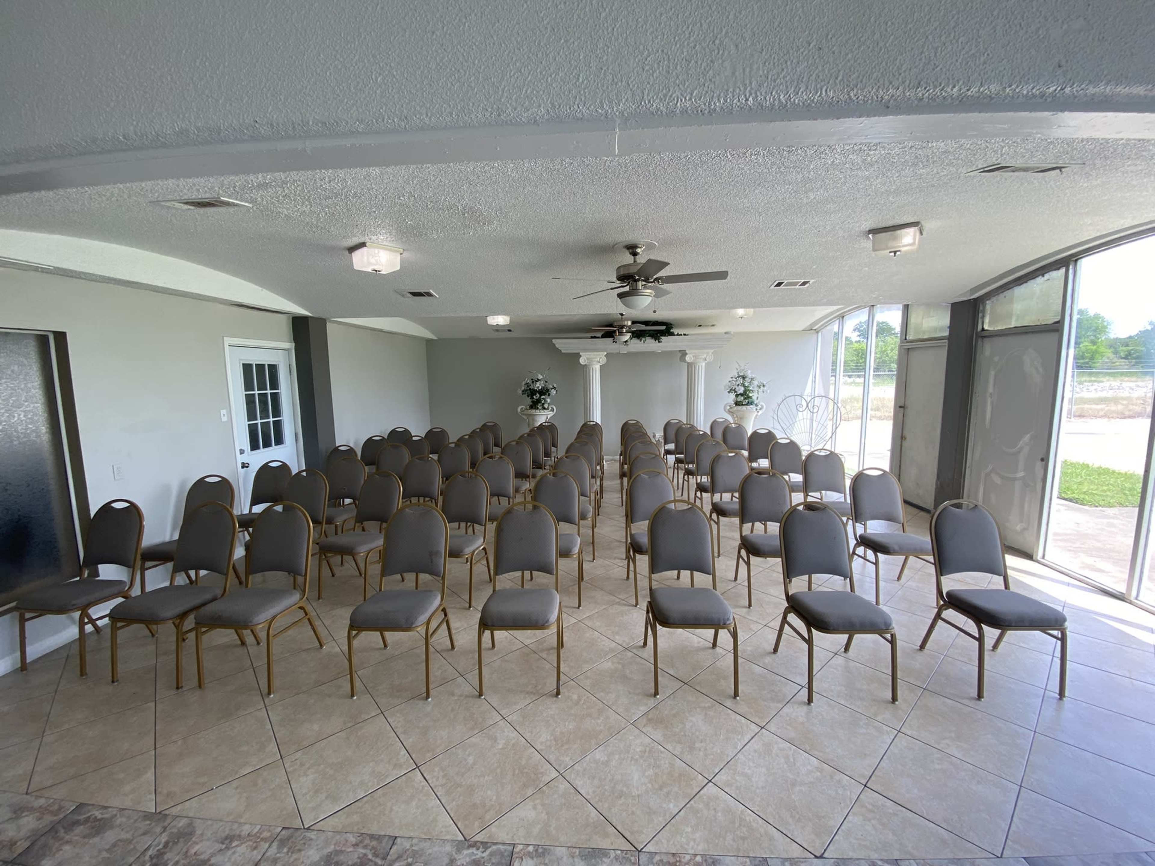 A spacious indoor venue set up with rows of empty chairs arranged for an event.