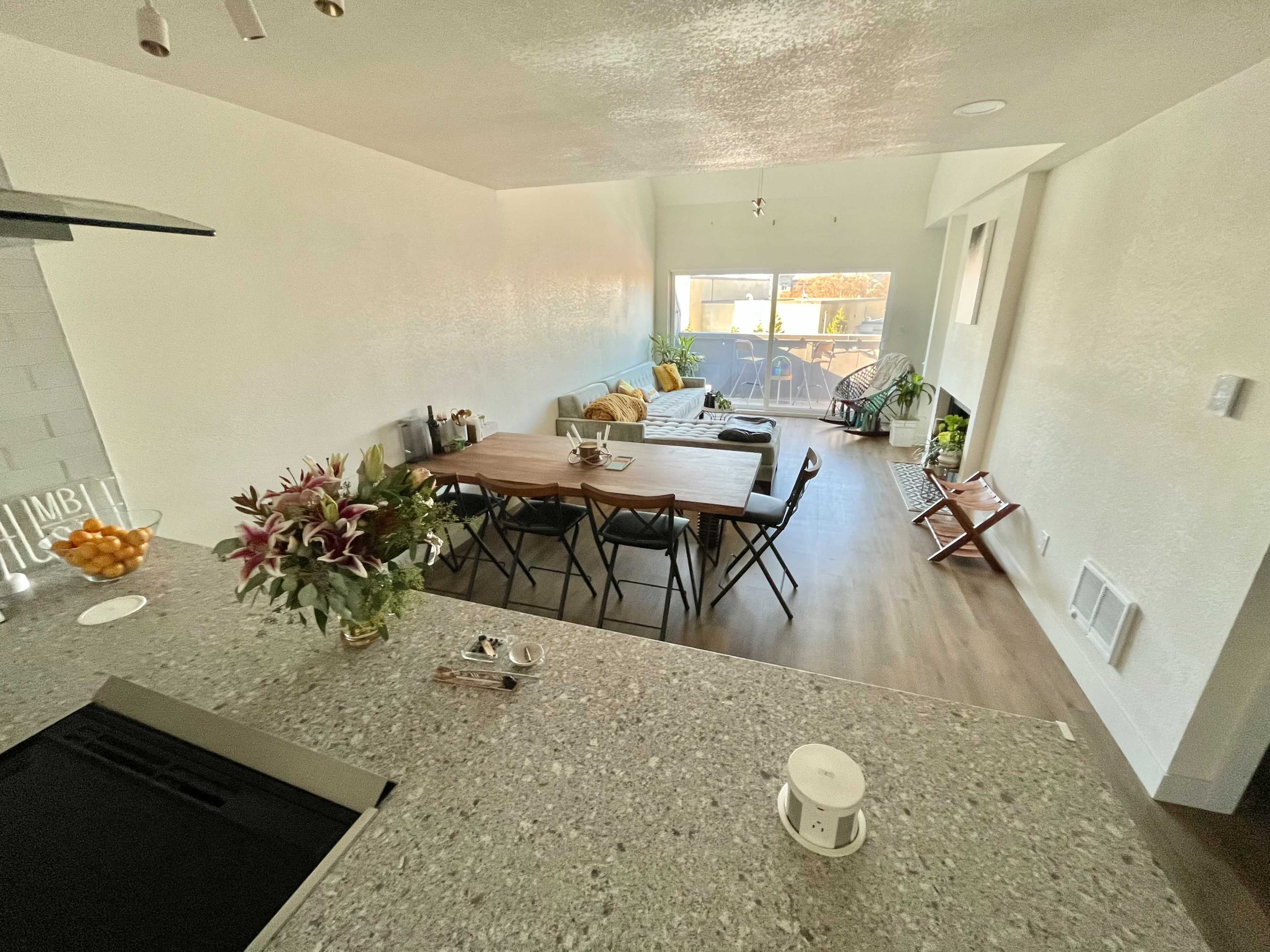 A modern, open-concept living and dining area with a dining table, chairs, and a seating area by a window.