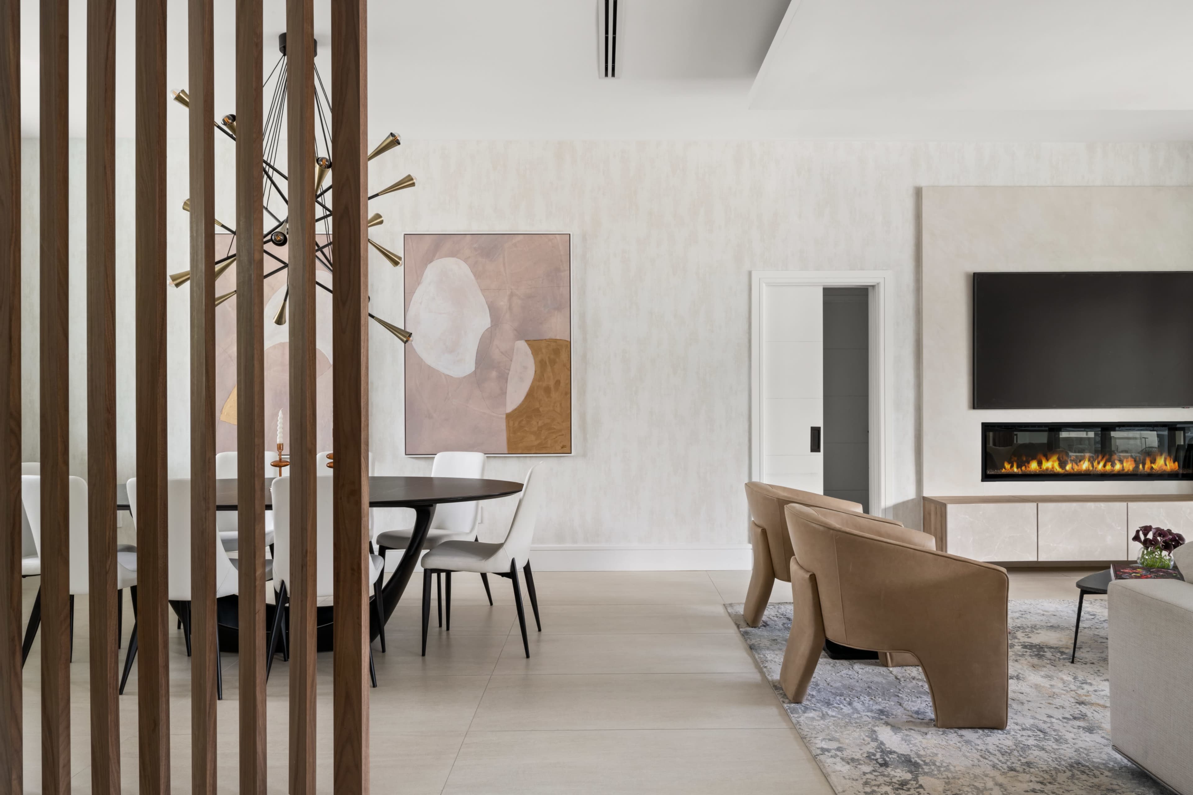 A modern living space features a dining area, a fireplace, and contemporary furniture with a neutral color palette.