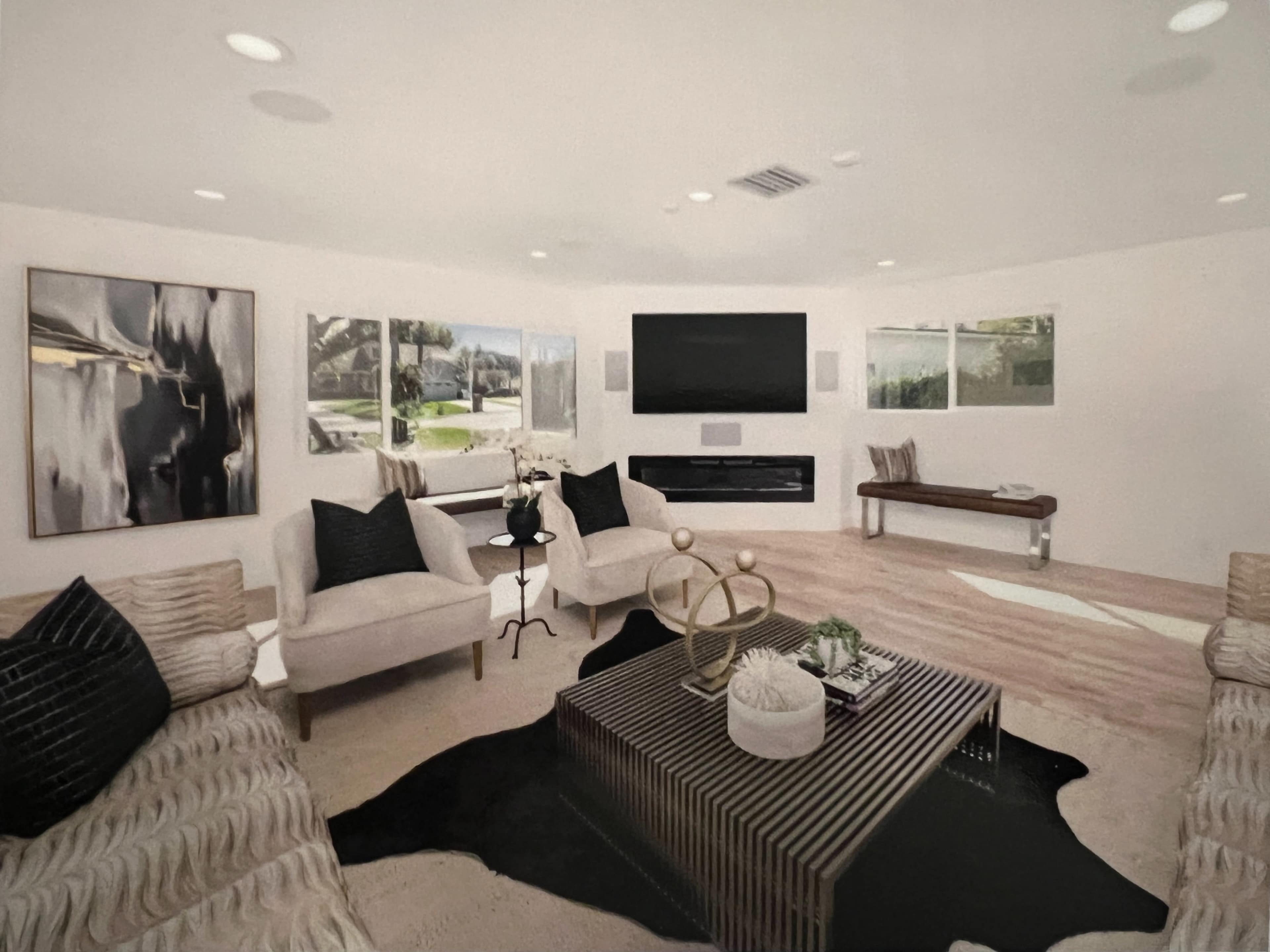 The image shows a modern living room with two chairs, a coffee table on a patterned rug, and a large TV mounted on the wall.