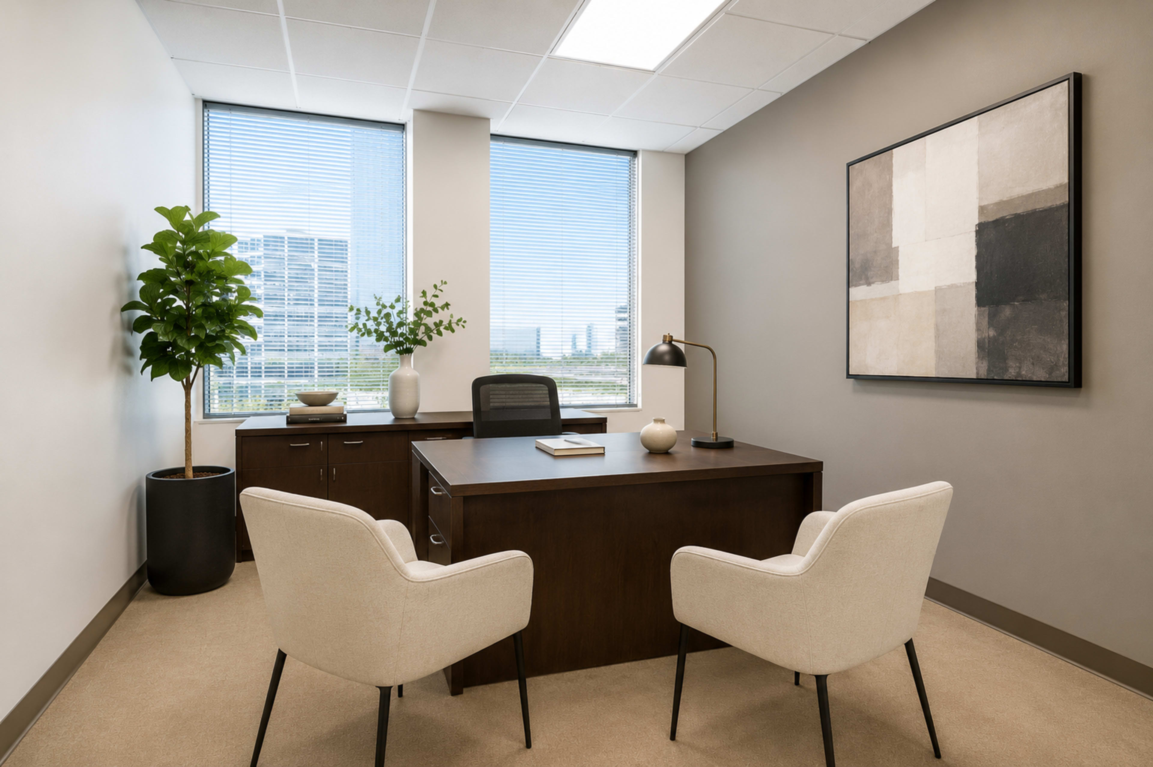 The image shows a modern office space featuring a wooden desk, two upholstered chairs, and large windows with a view of a cityscape.