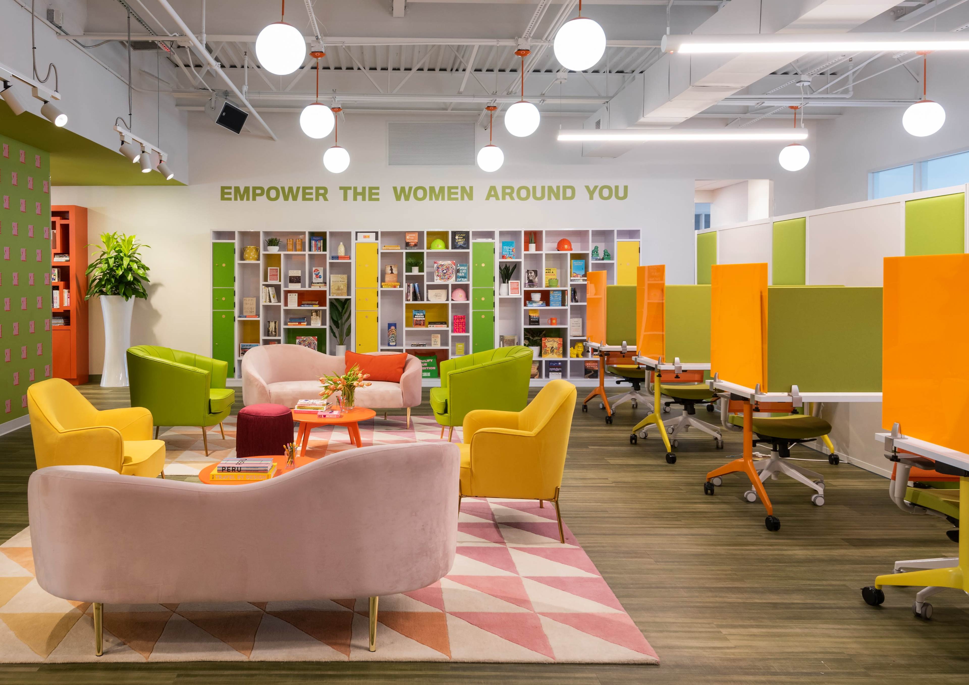 The image shows a brightly colored, modern workspace with seating areas and bookshelves, designed for collaboration and support.