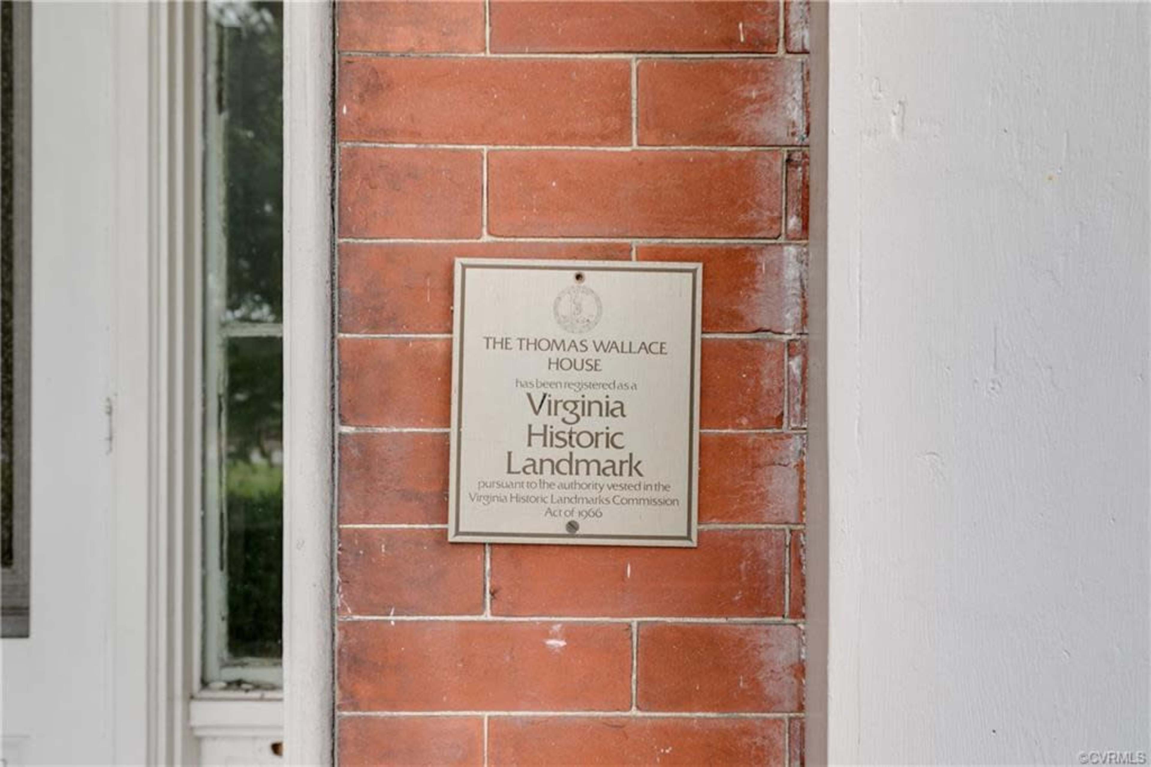 A plaque on a brick wall indicates that the Thomas Wallace House is a designated Virginia Historic Landmark.