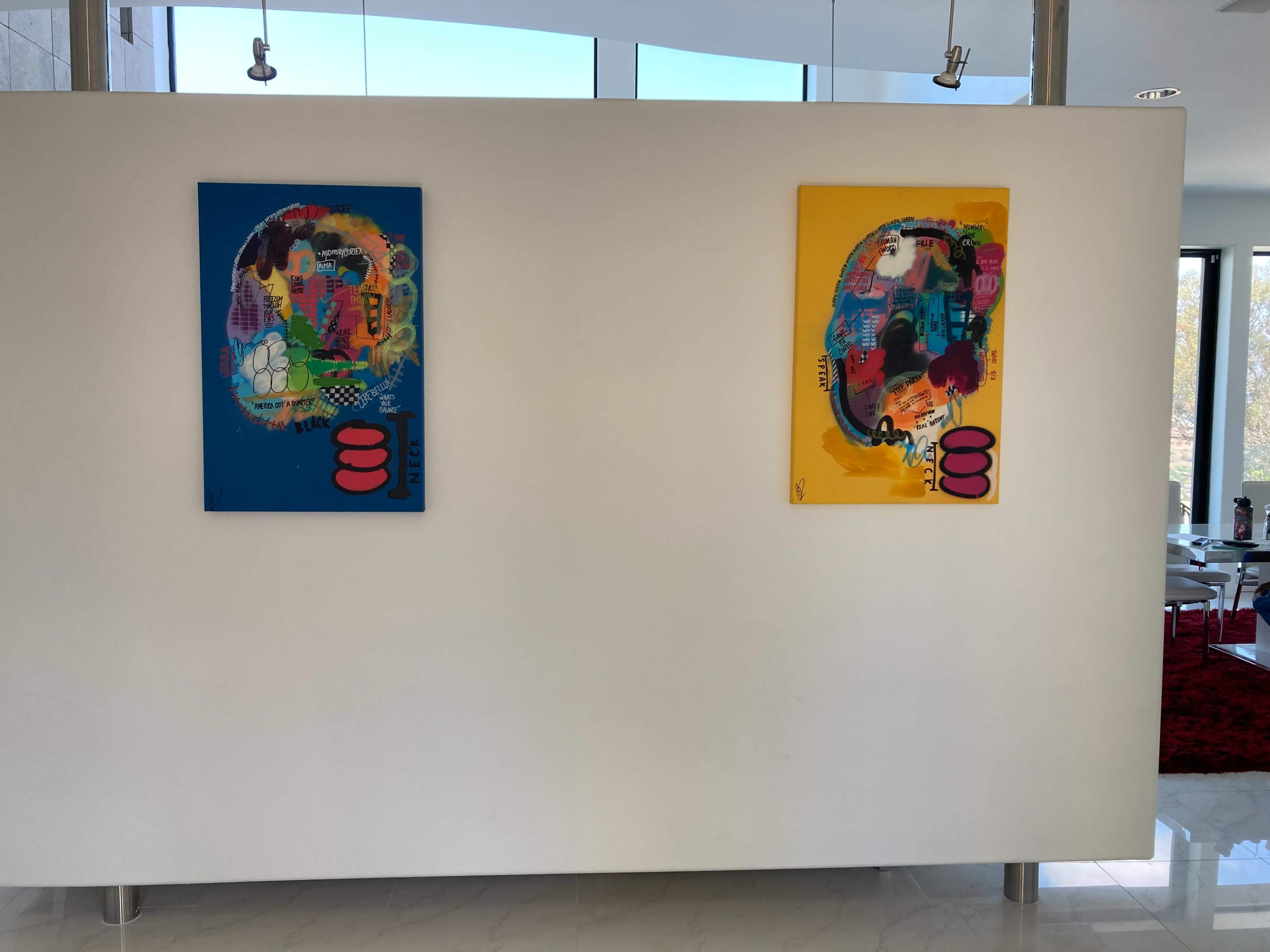 Two colorful abstract paintings mounted on a white wall in a modern interior space.