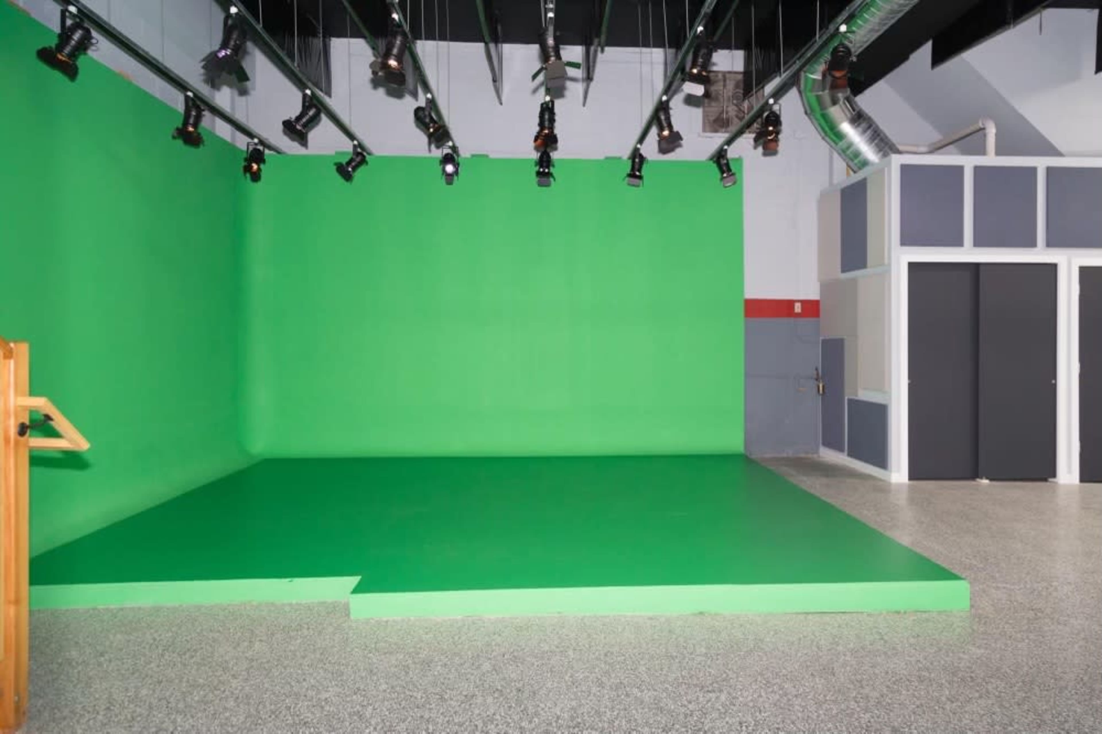 A green screen studio with a smooth green backdrop and overhead lighting.