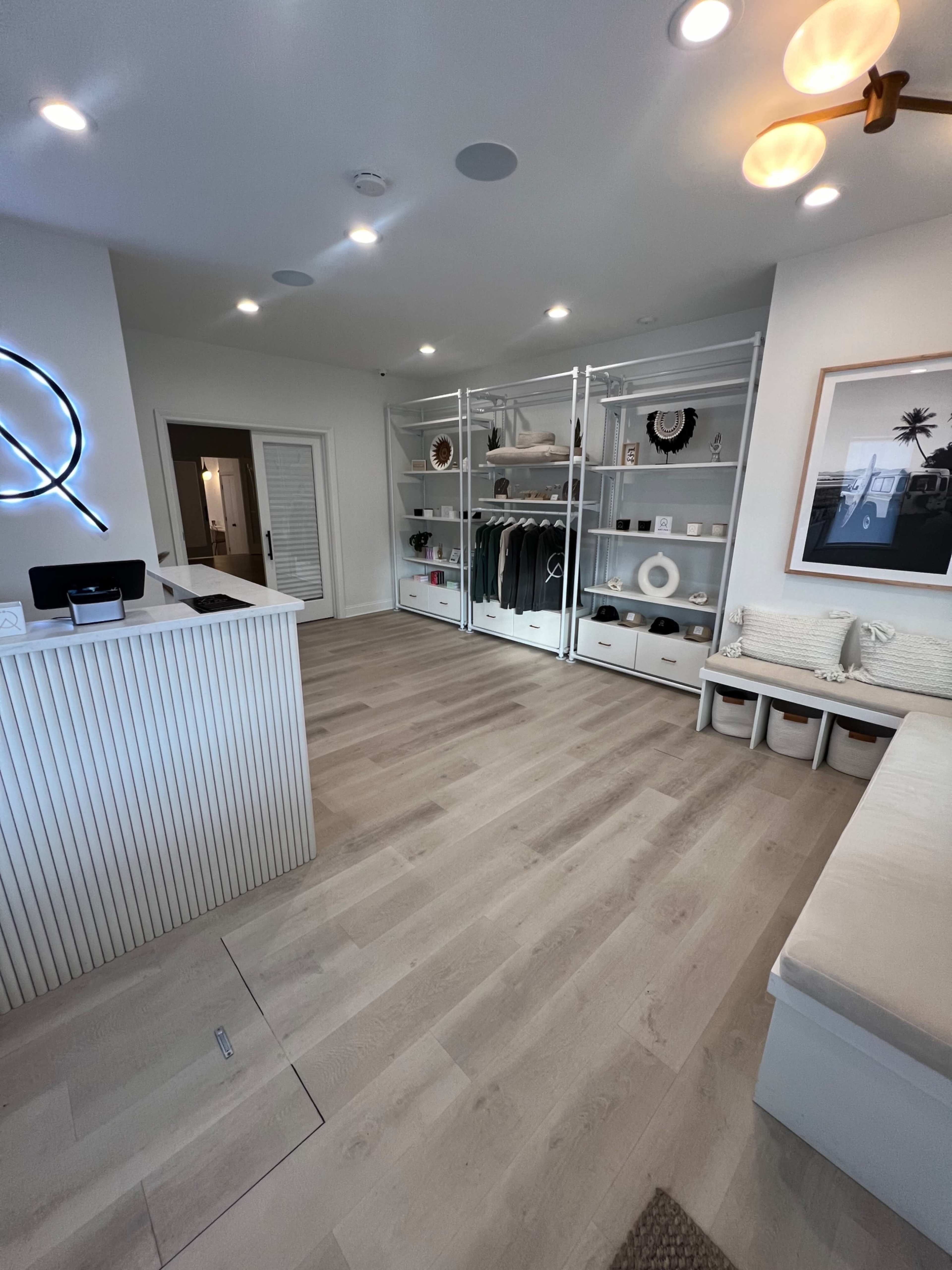 A bright, modern retail space with a reception area on the left and neatly organized shelving displaying products on the right.