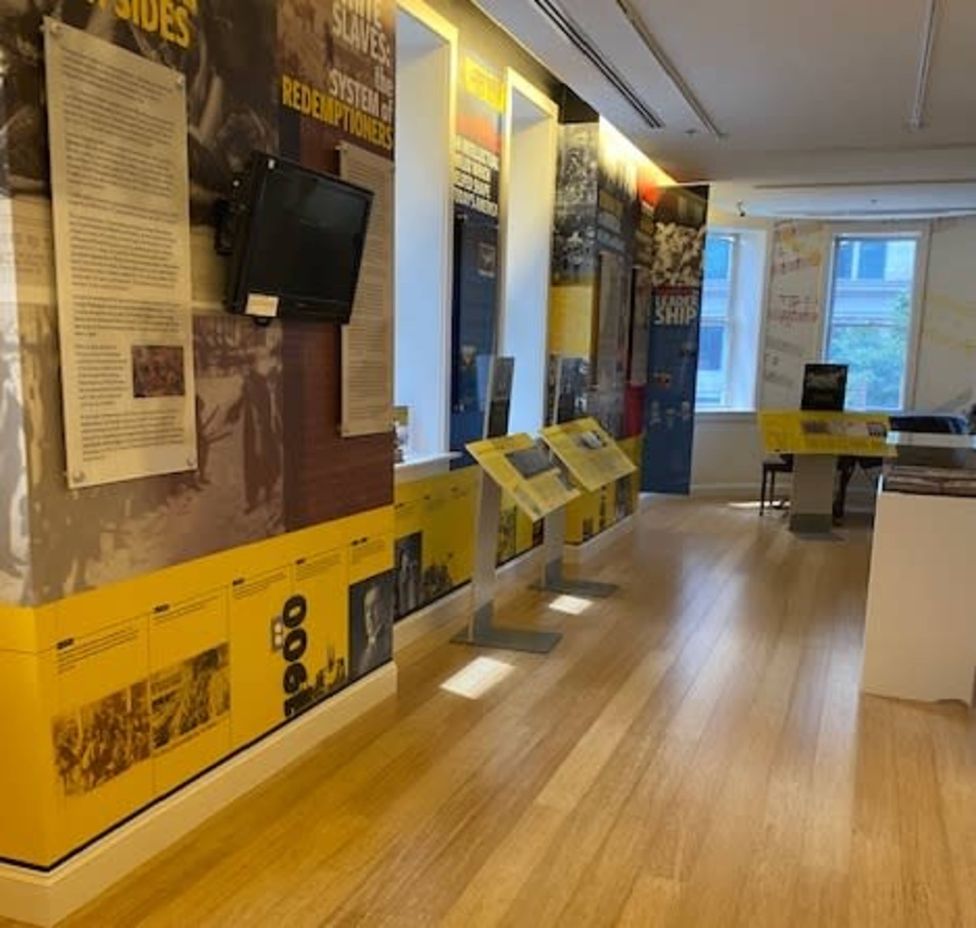 An interior exhibit with informative panels and displays on the walls, highlighting historical themes related to slavery and redemption.