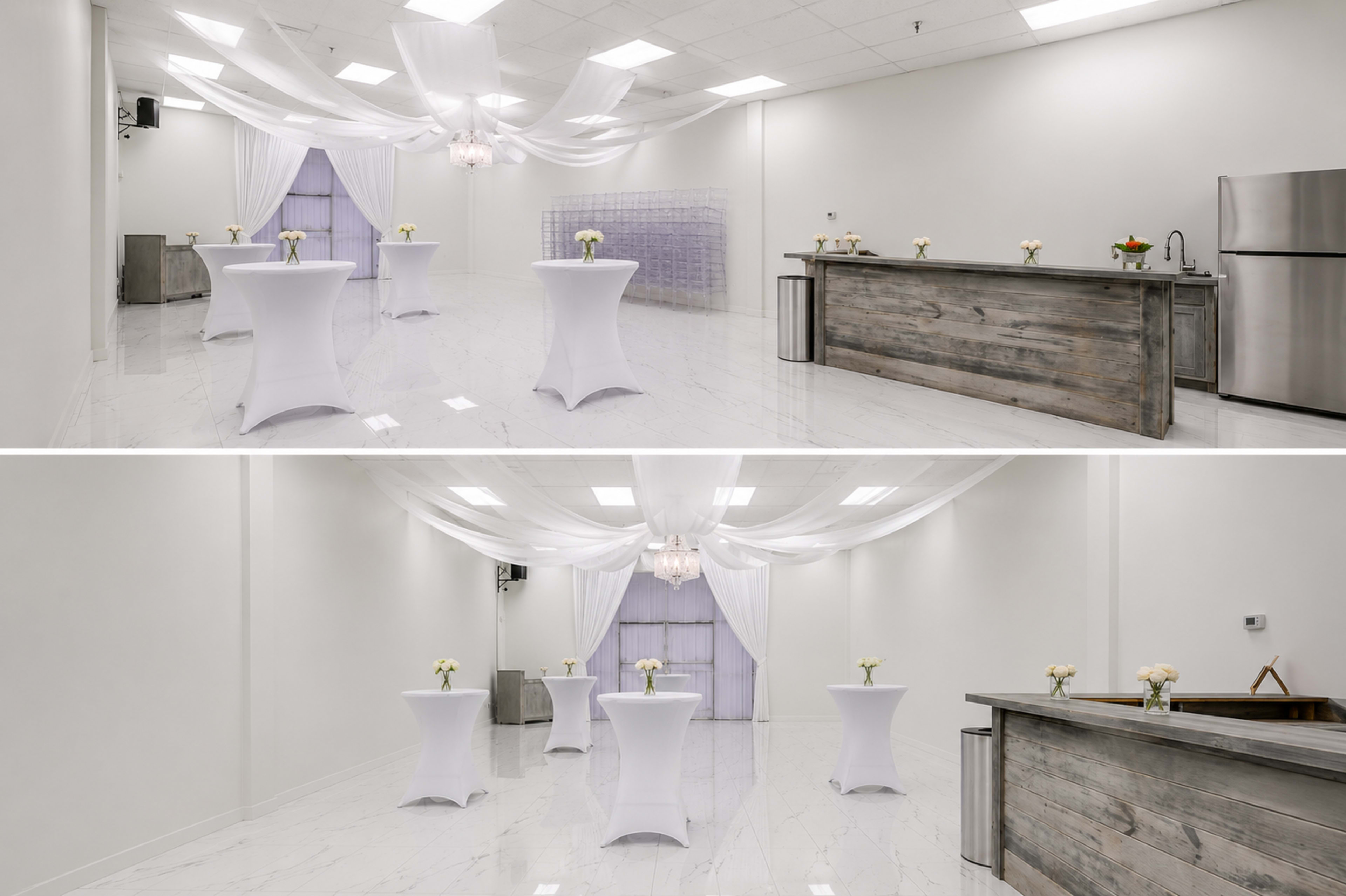 The image shows a spacious, elegantly arranged event room with white tables and a wooden bar, featuring decorative drapery and floral centerpieces.
