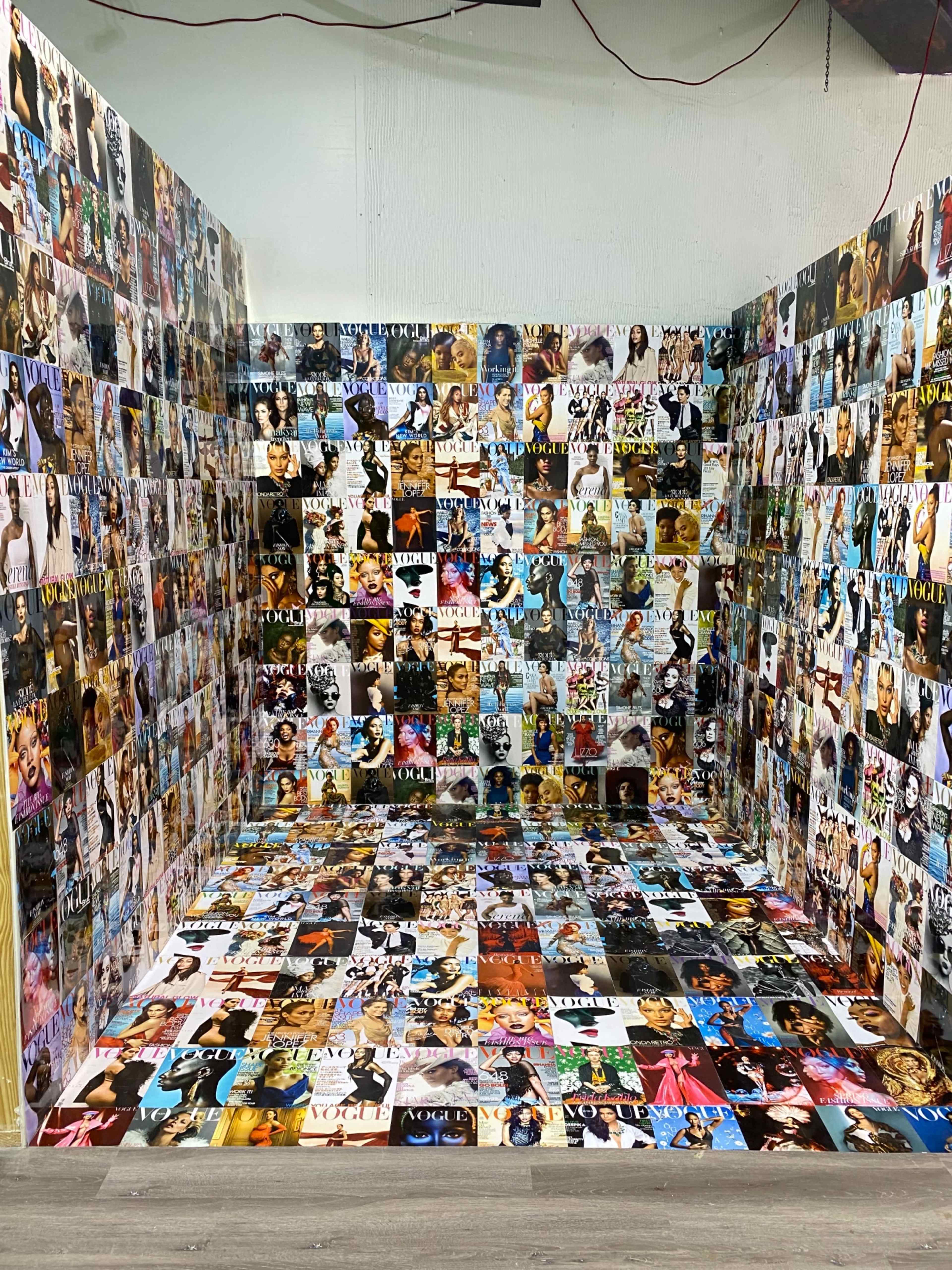 A room with walls and floor covered in a collage of various magazine covers and photo prints.
