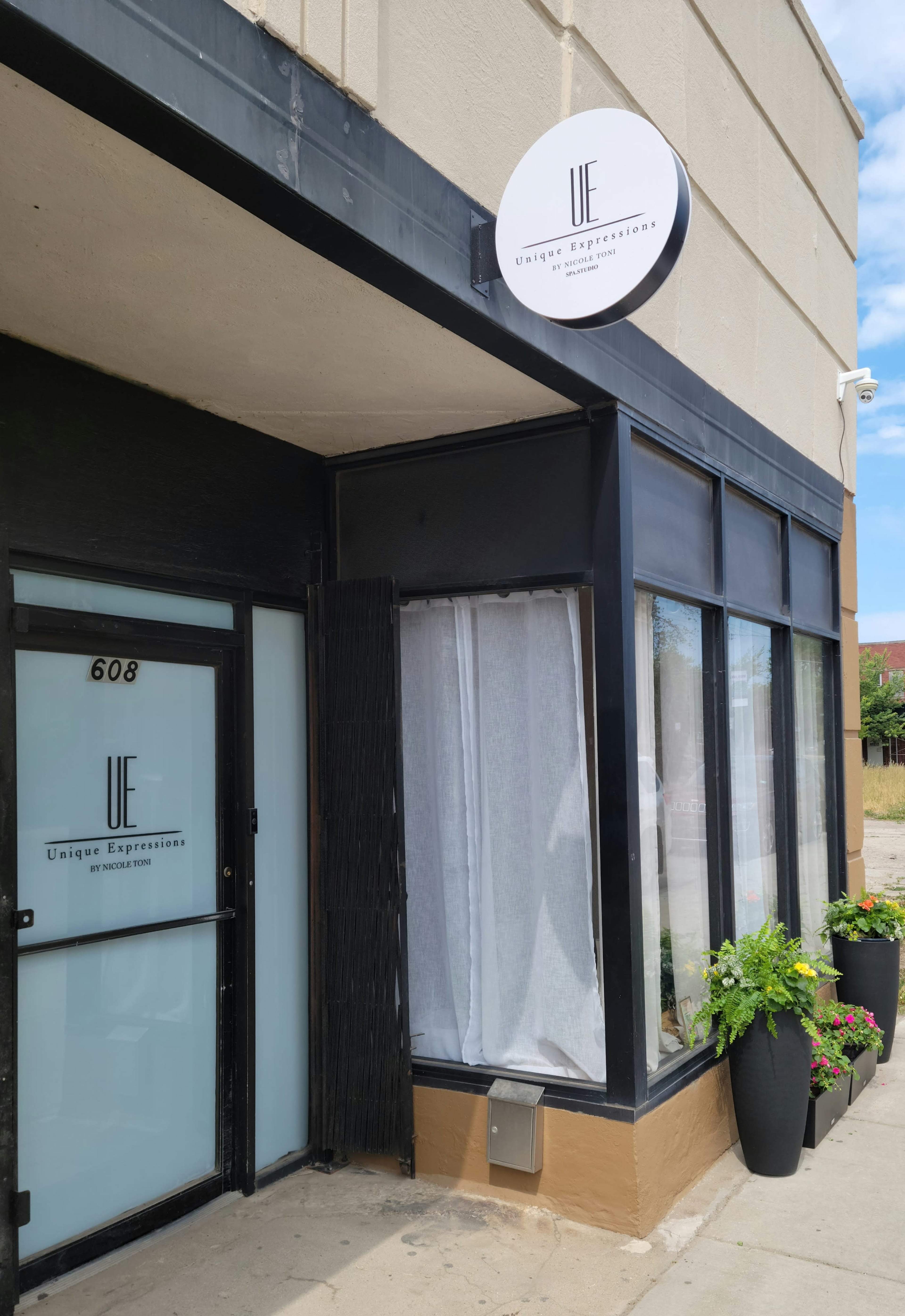 The entrance of a storefront with a sign that reads "Unique Expressions" above the door.