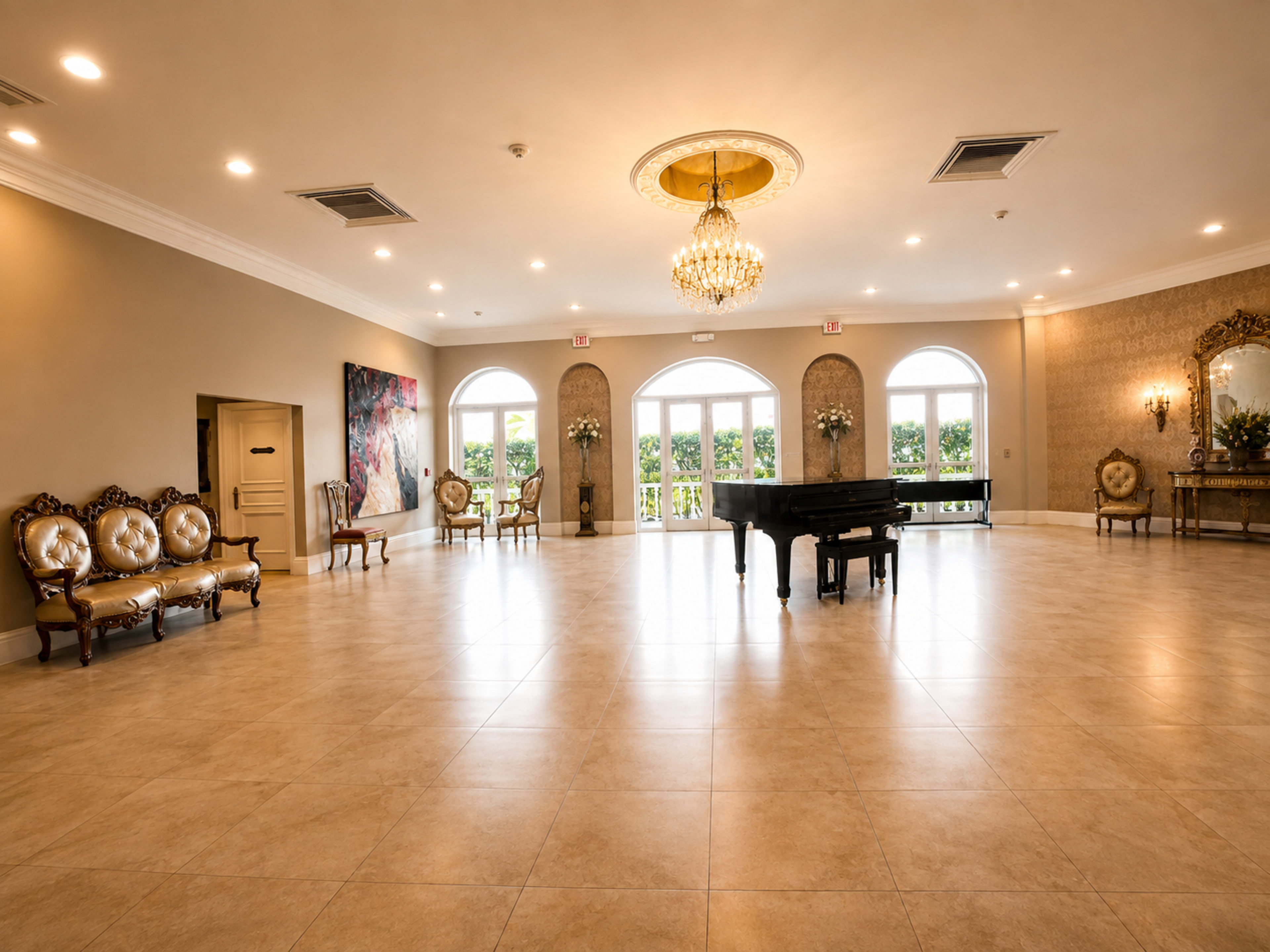 The image shows a spacious event hall with a grand piano, elegant seating, and large windows allowing natural light to enter.