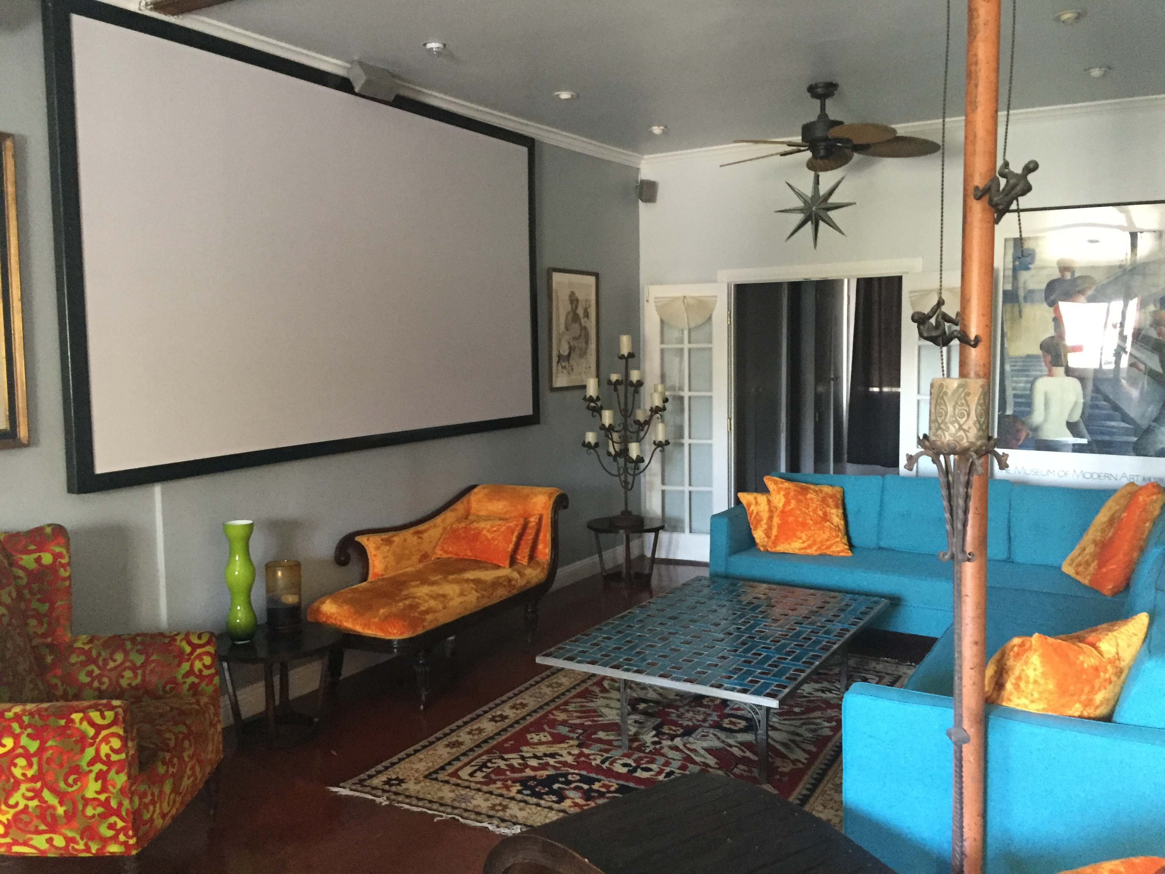 The room features a large projection screen, colorful seating arrangements, and decorative accents on a polished floor.