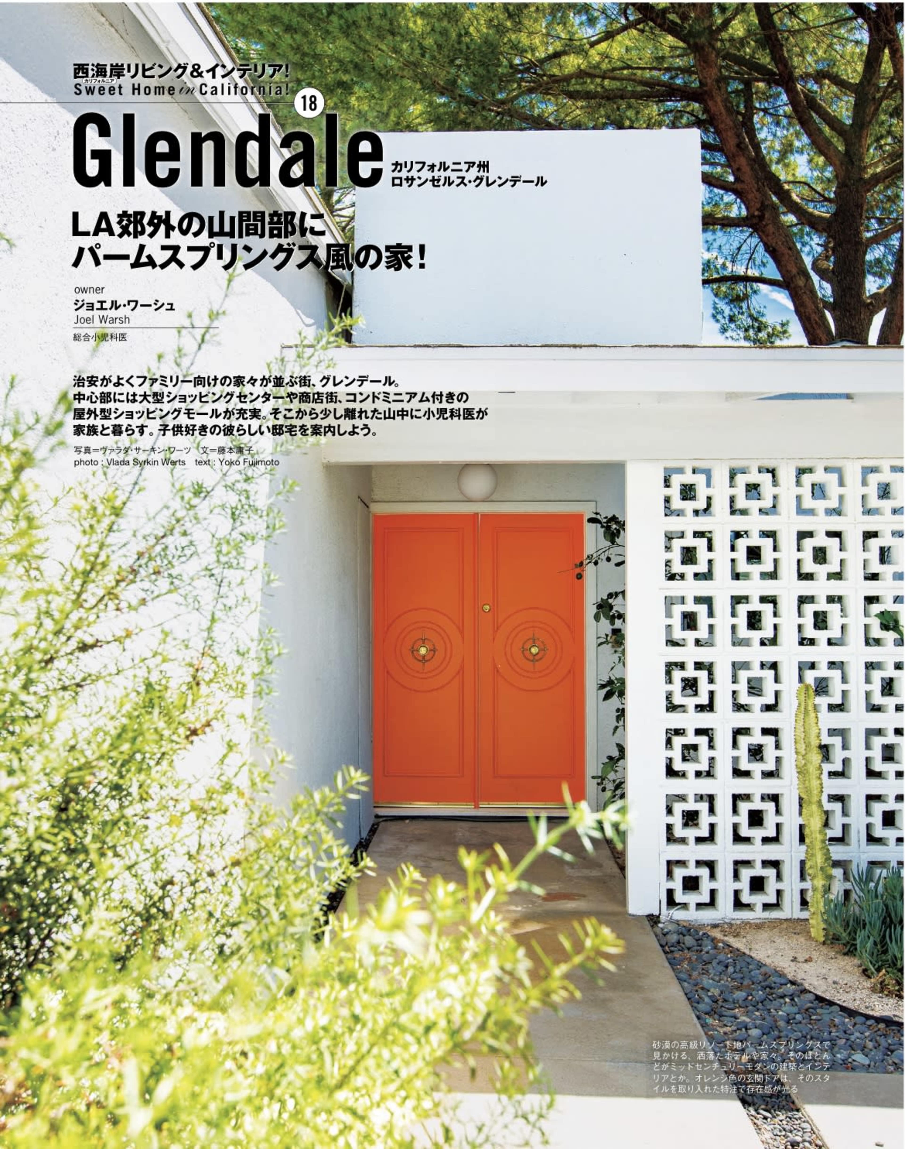 A modern house exterior with an orange double door and a decorative white wall pattern.