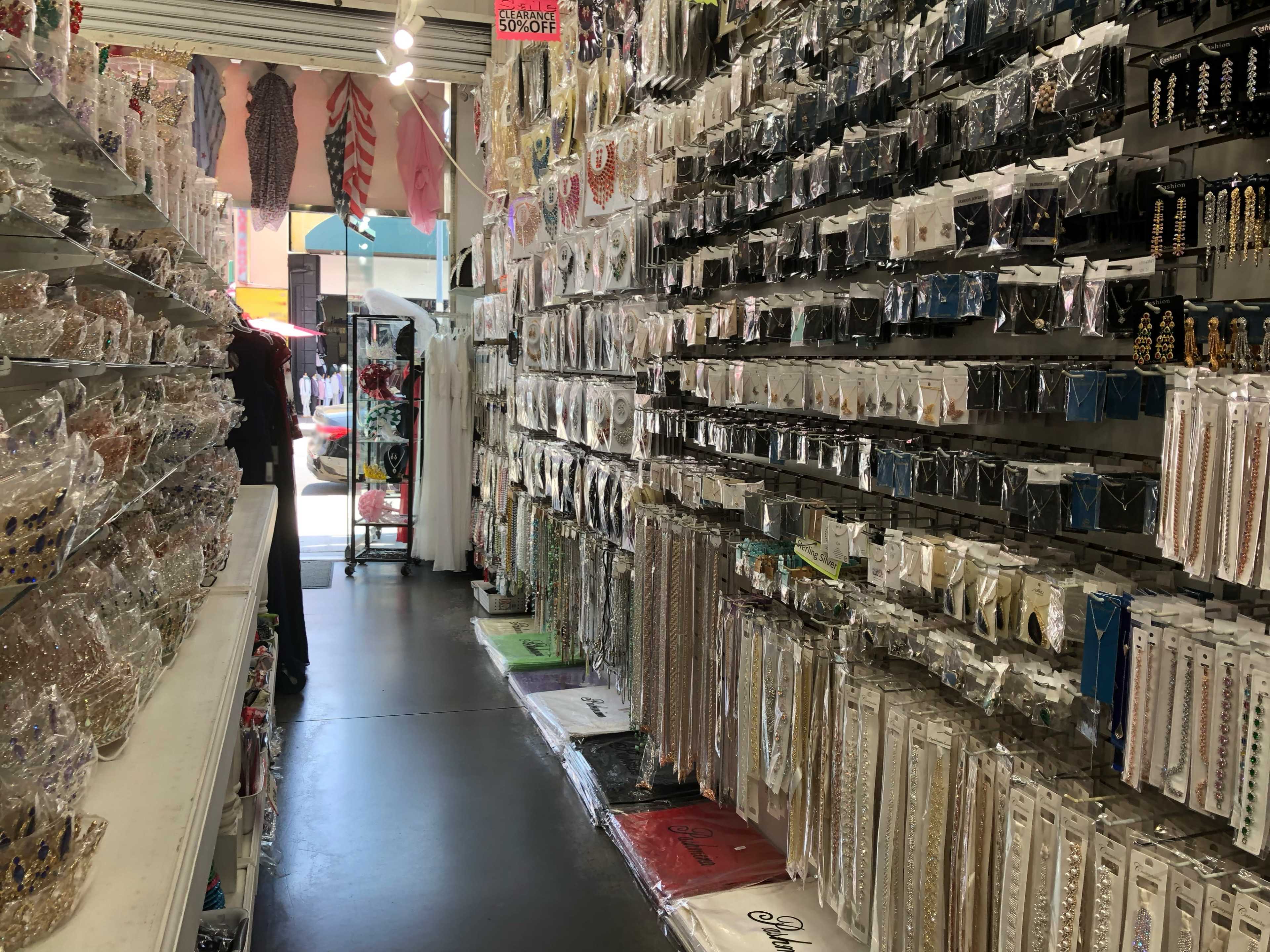 The image shows a narrow aisle in a store lined with shelves filled with various decorative accessories and embellishments.