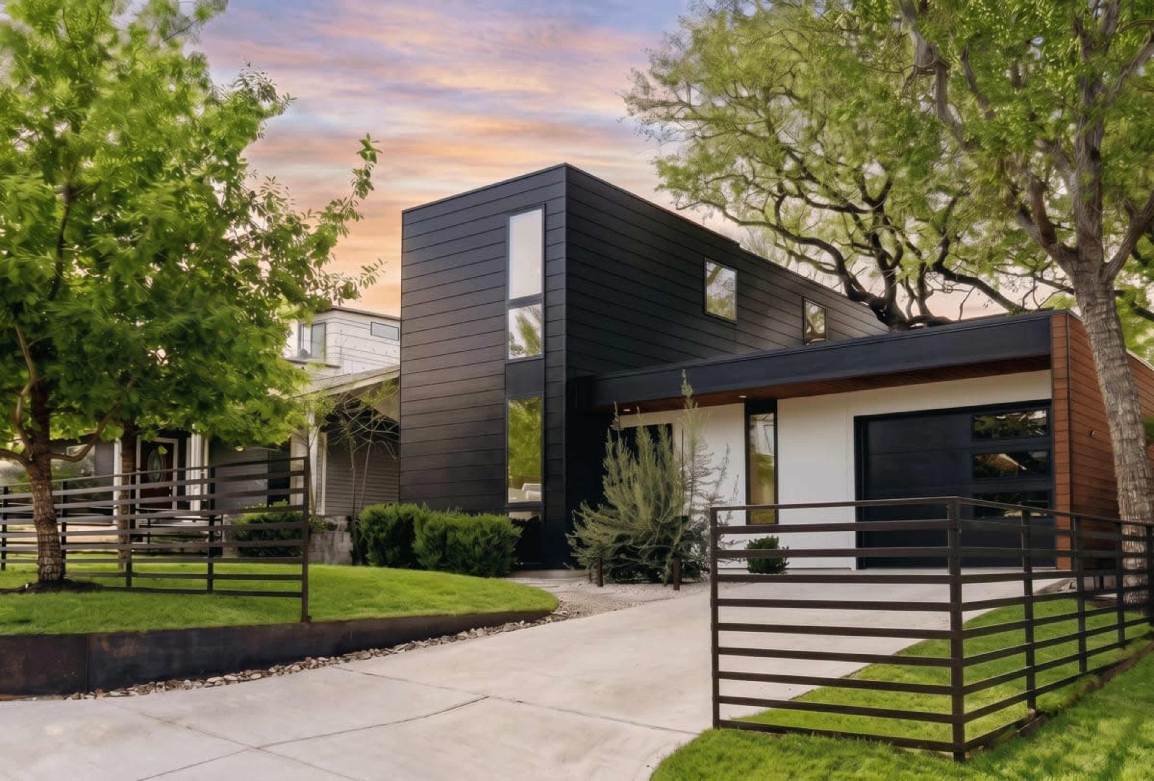 The image shows a modern two-story house with a black exterior located on a landscaped property featuring a curved driveway and surrounding greenery.