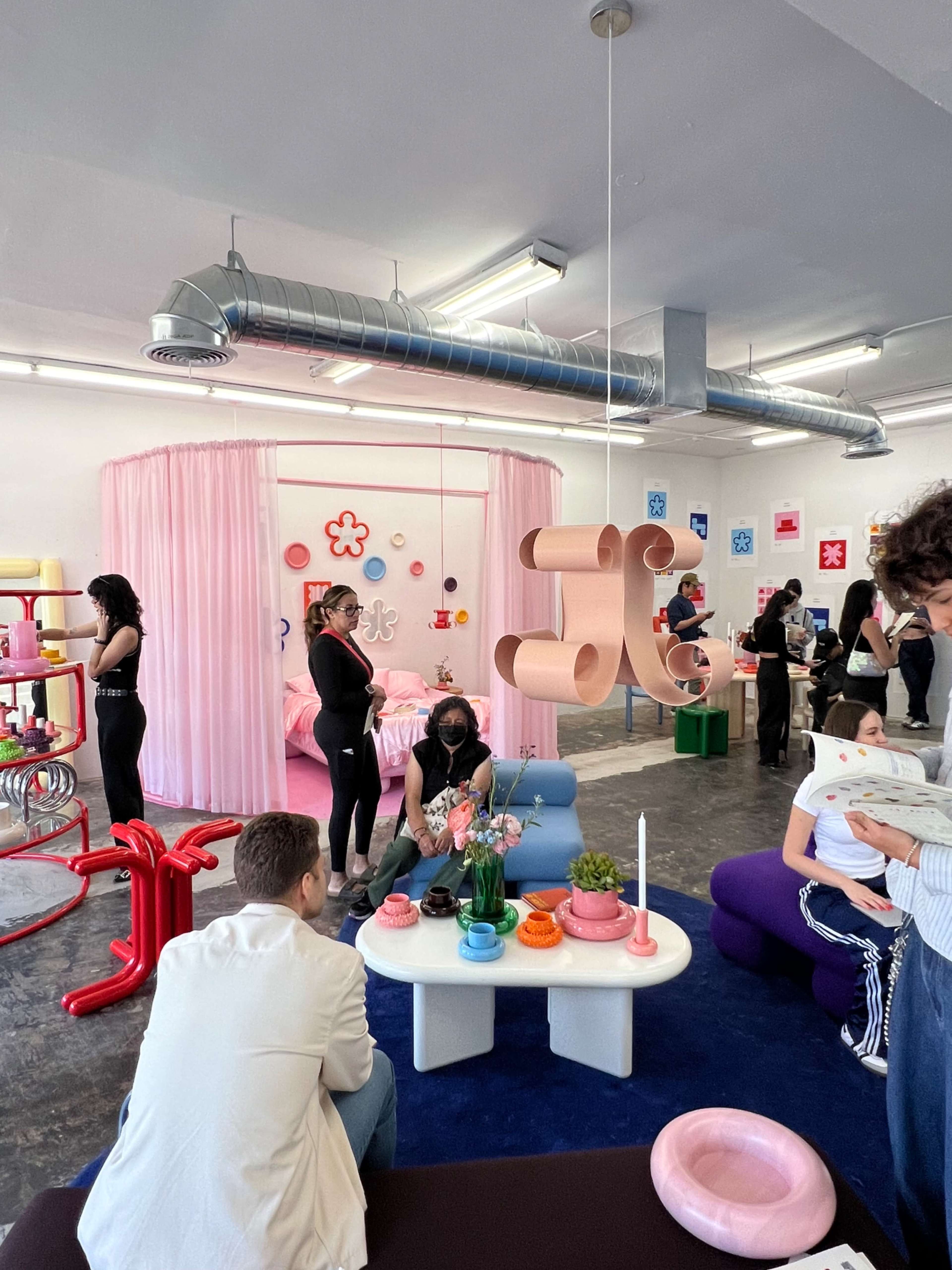 A bright, modern room features people engaged in various activities surrounded by colorful furniture and decor.