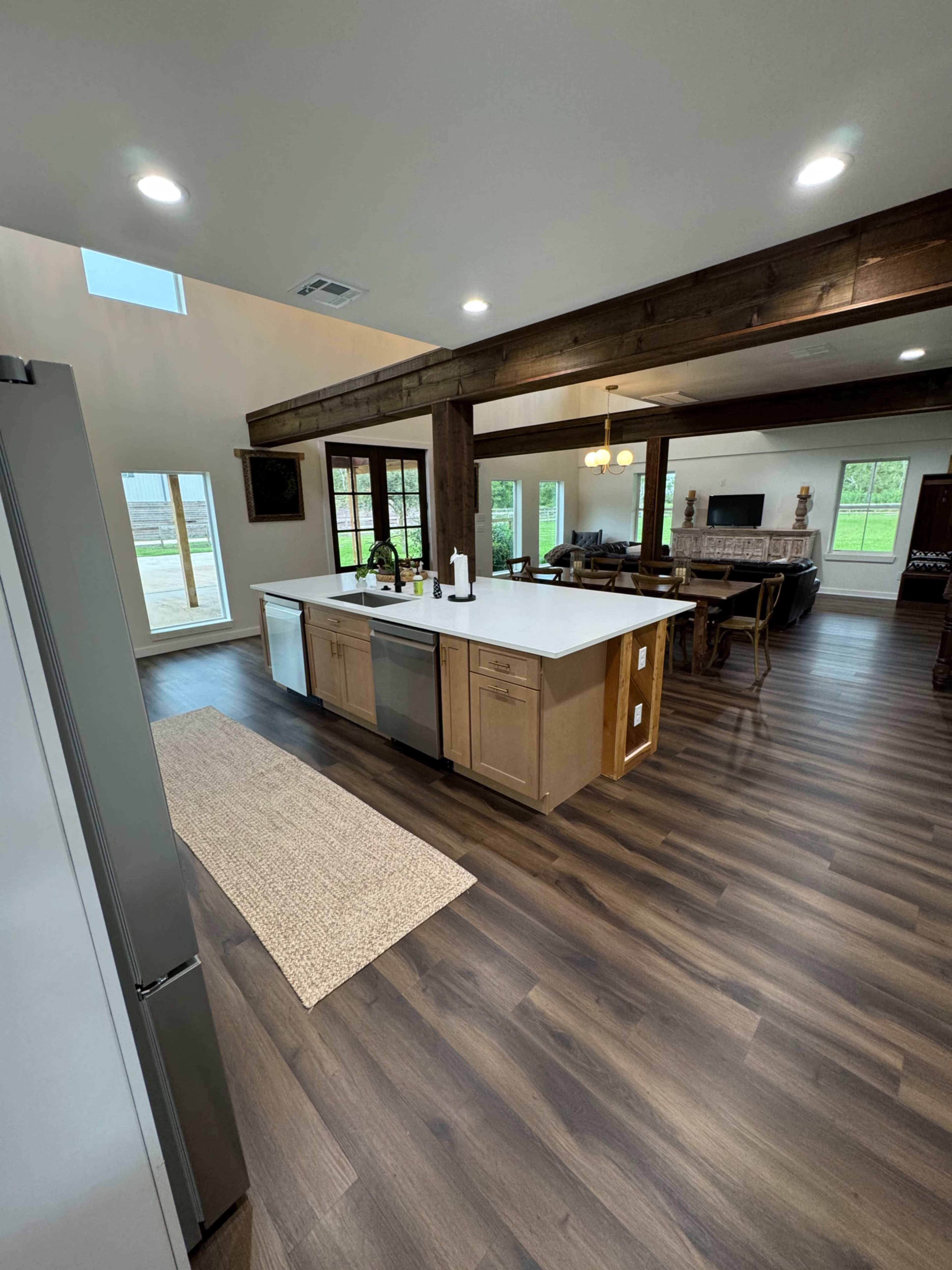 A spacious kitchen with a large island, hardwood floors, and windows that provide natural light.