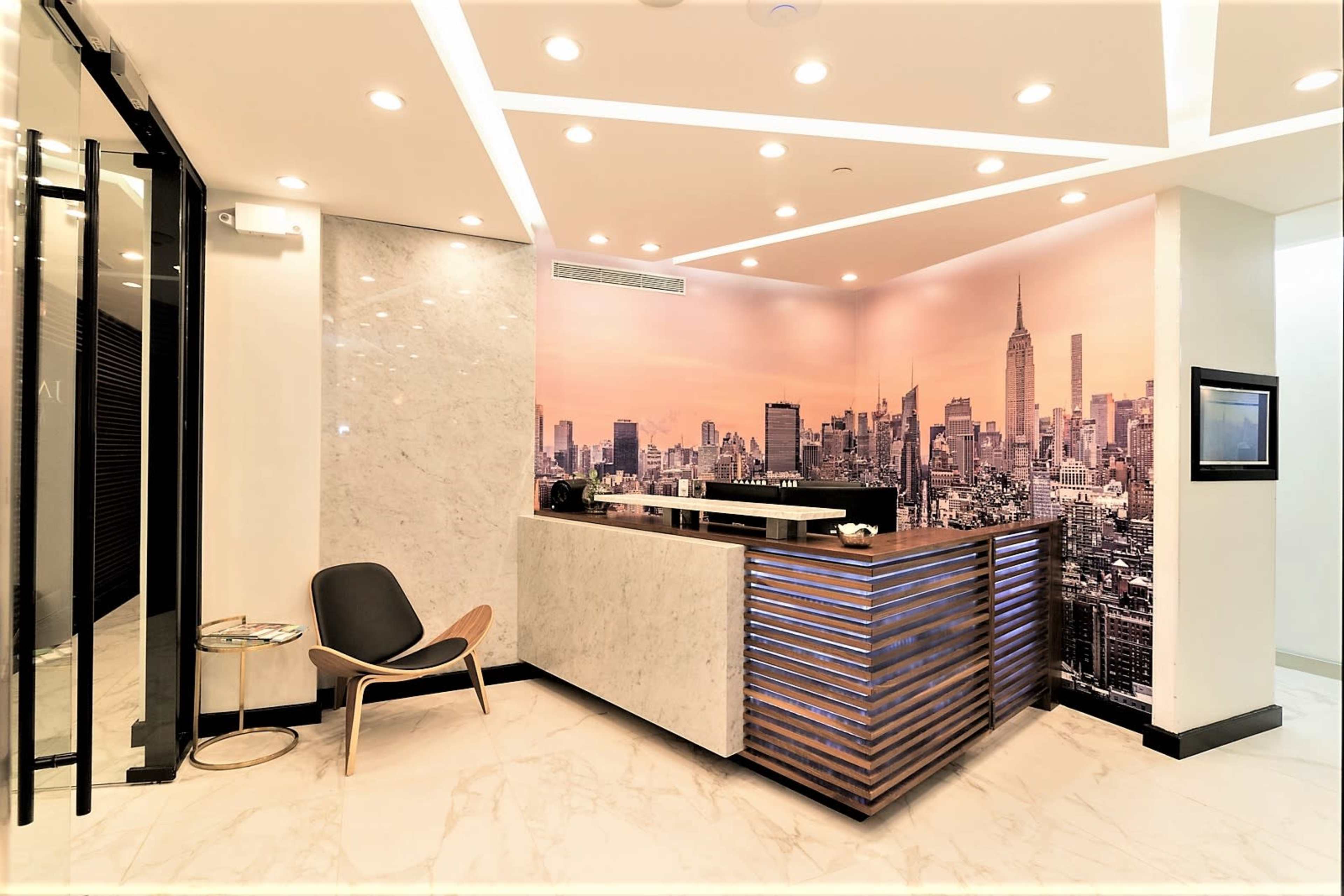 The image shows a modern reception area with a marble counter and a cityscape mural featuring New York City.