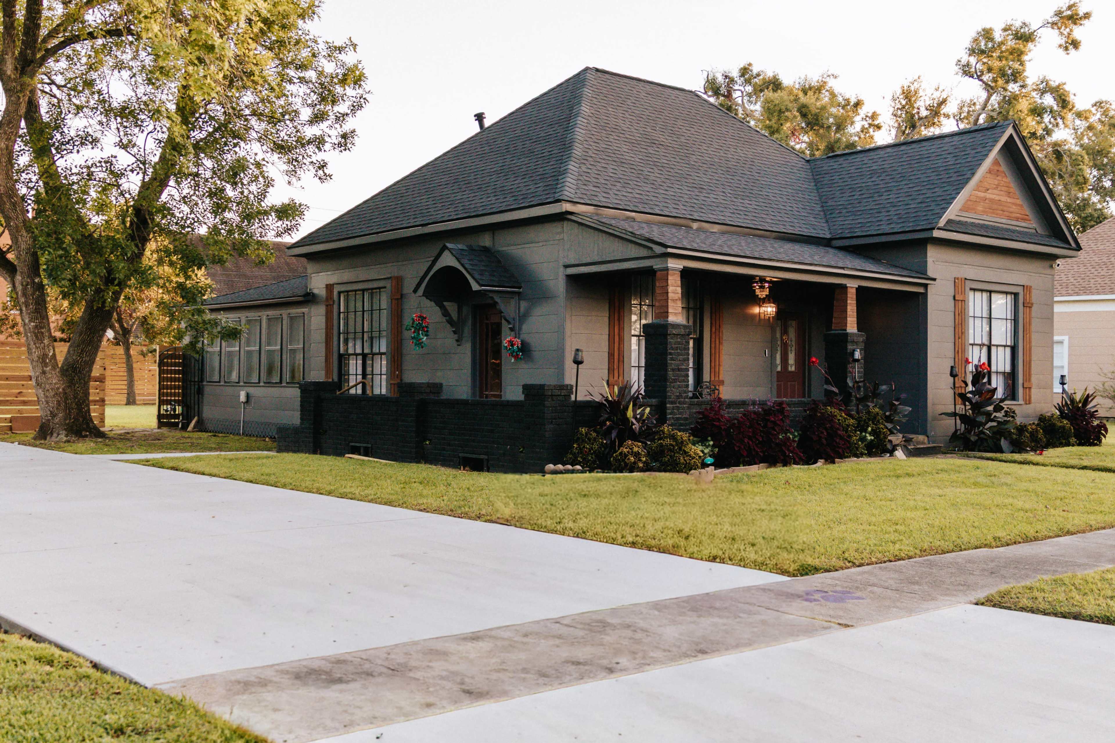 The image shows a single-story house with a front porch, surrounded by a lawn and featuring decorative holiday wreaths on the windows.